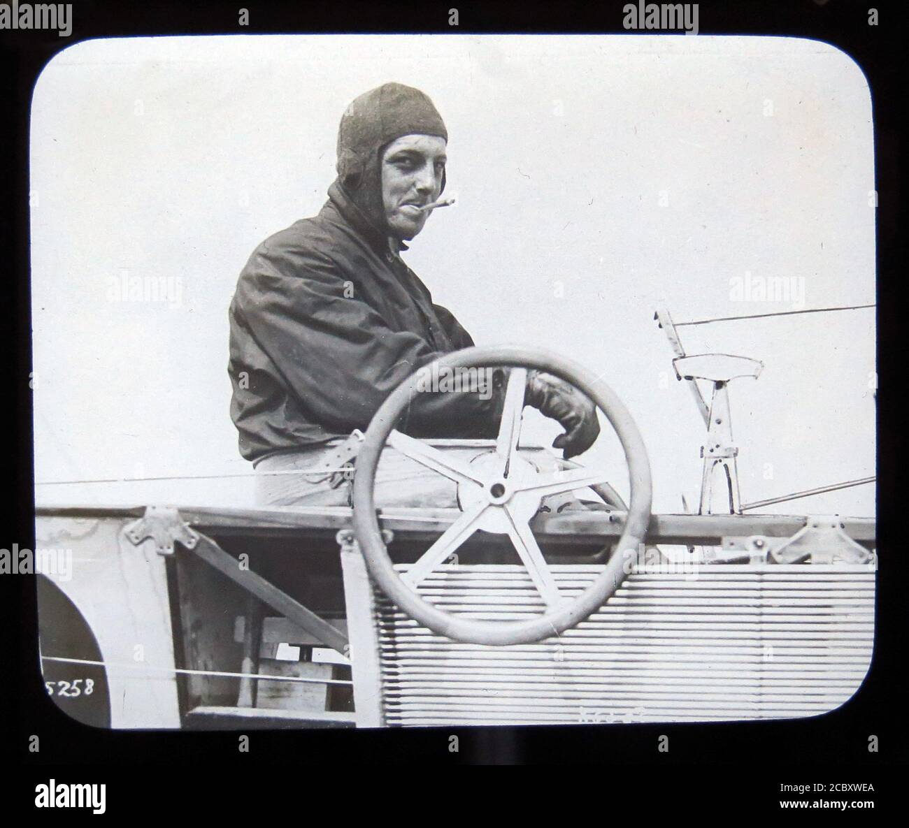 Une diapositive magique représentant l'aviateur anglo-français Hubert Latham, dans son monoplan Antoinette. Il a été la première personne à tenter de traverser la Manche dans un avion. En raison d'une panne de moteur lors de sa première des deux tentatives de traverser la Manche, il est devenu la première personne à atterrir un avion sur un plan d'eau. Diapositive publiée par W. Butcher & Sons, Londres et datant d'environ 1914. Banque D'Images