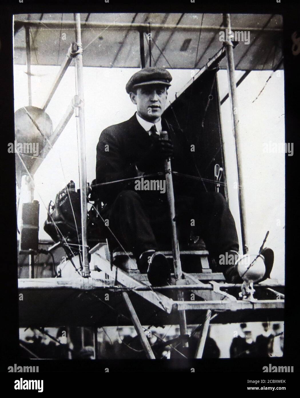 Une diapositive magique représentant l'aviateur pionnier Cecil Grace dans son court biplan S.27. Grace était un américain naturalisé en tant que citoyen britannique en octobre 1910. Il a été l'un des premiers aviateurs pionniers qui, en avril 1910, n'a reçu que le quatrième certificat d'aviateur du Royal Aero Club. Il a disparu lors d'un vol à travers la Manche le 22 décembre 1910. Diapositive publiée par W. Butcher & Sons, Londres et datant d'environ 1914. Banque D'Images