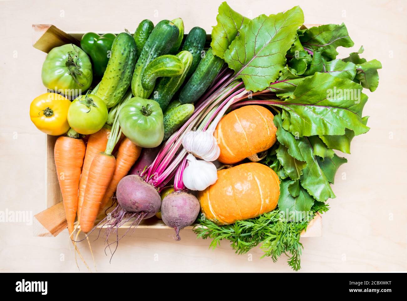 Vue de dessus légumes frais biologiques dans caisse en bois écologique sur fond de bois. plat Banque D'Images
