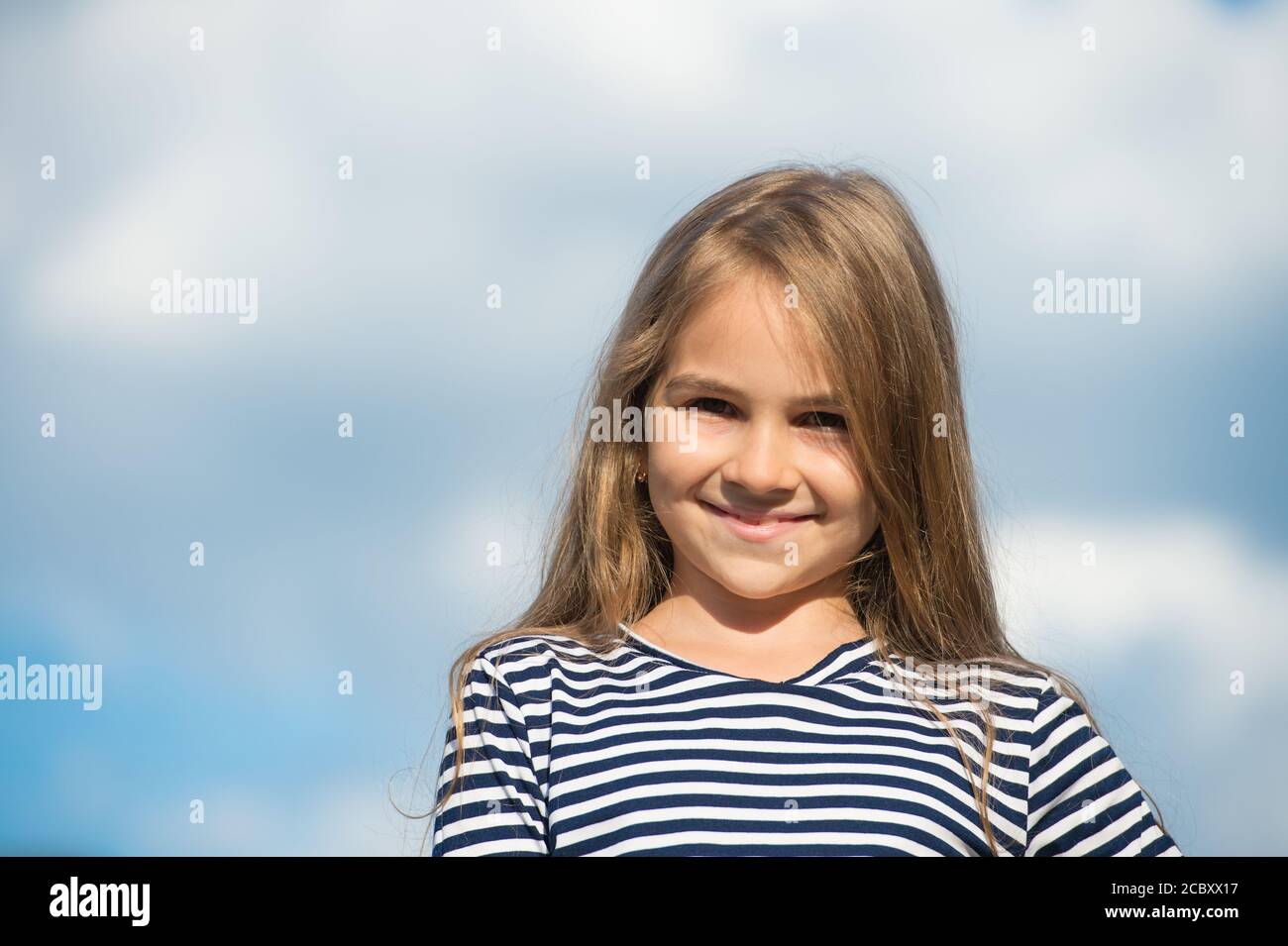 Souriez en toute confiance. Joyeux sourire d'enfant sur ciel nuageux. Petit enfant avec un sourire mignon. Santé des dents. Soins dentaires. Hygiène bucco-dentaire. Dentisterie pédiatrique. Dépensez moins sur votre dentiste, l'espace de copie. Banque D'Images