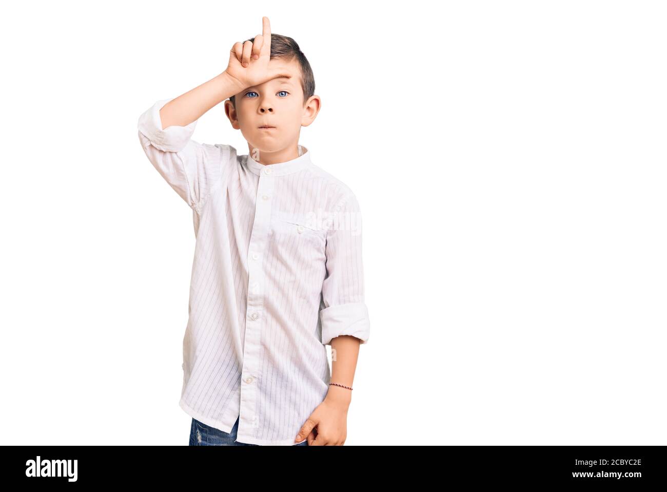 Mignon blond enfant portant une chemise élégante rendant amusant de personnes avec les doigts sur le front faisant le mocking de geste perdant et insultant. Banque D'Images