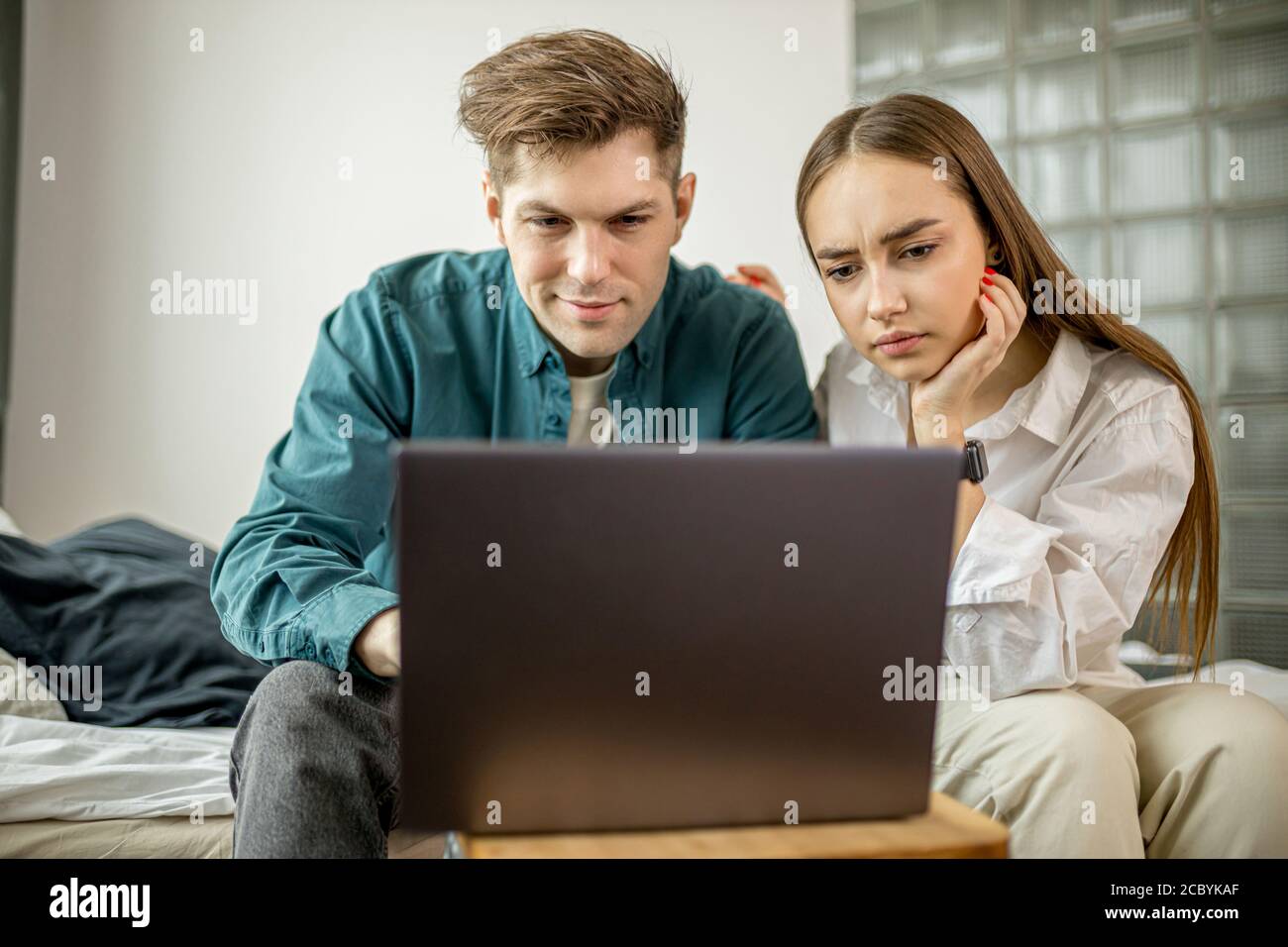 un jeune couple caucasien regarde un film sur ordinateur portable a la maison homme et femme en tenue domestique passent du temps libre ensemble. a l interieur Photo Stock Alamy