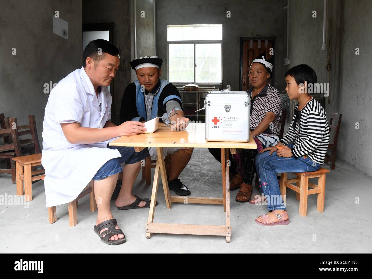 (200817) -- NANDAN, le 17 août 2020 (Xinhua) -- le docteur du village Li mou(1er L) rend visite à la famille de Li Zhiming dans leur nouvelle maison à l'intérieur d'un site de relocalisation de l'aide à la pauvreté pour le peuple Baiku Yao dans le comté de Nandan, dans la région autonome de Guangxi Zhuang, dans le sud de la Chine, le 6 août 2020. Situé dans la partie nord-ouest du Guangxi, le comté de Nandan est connu pour le peuple Baiku Yao, une minorité ethnique connue pour son pantalon blanc. La minorité a conservé sa culture intacte et est surnommée comme un « fossile vivant » de la civilisation humaine. La Chine compte environ 50,000 Baiku Yao, dont 42,000 résident à Na Banque D'Images