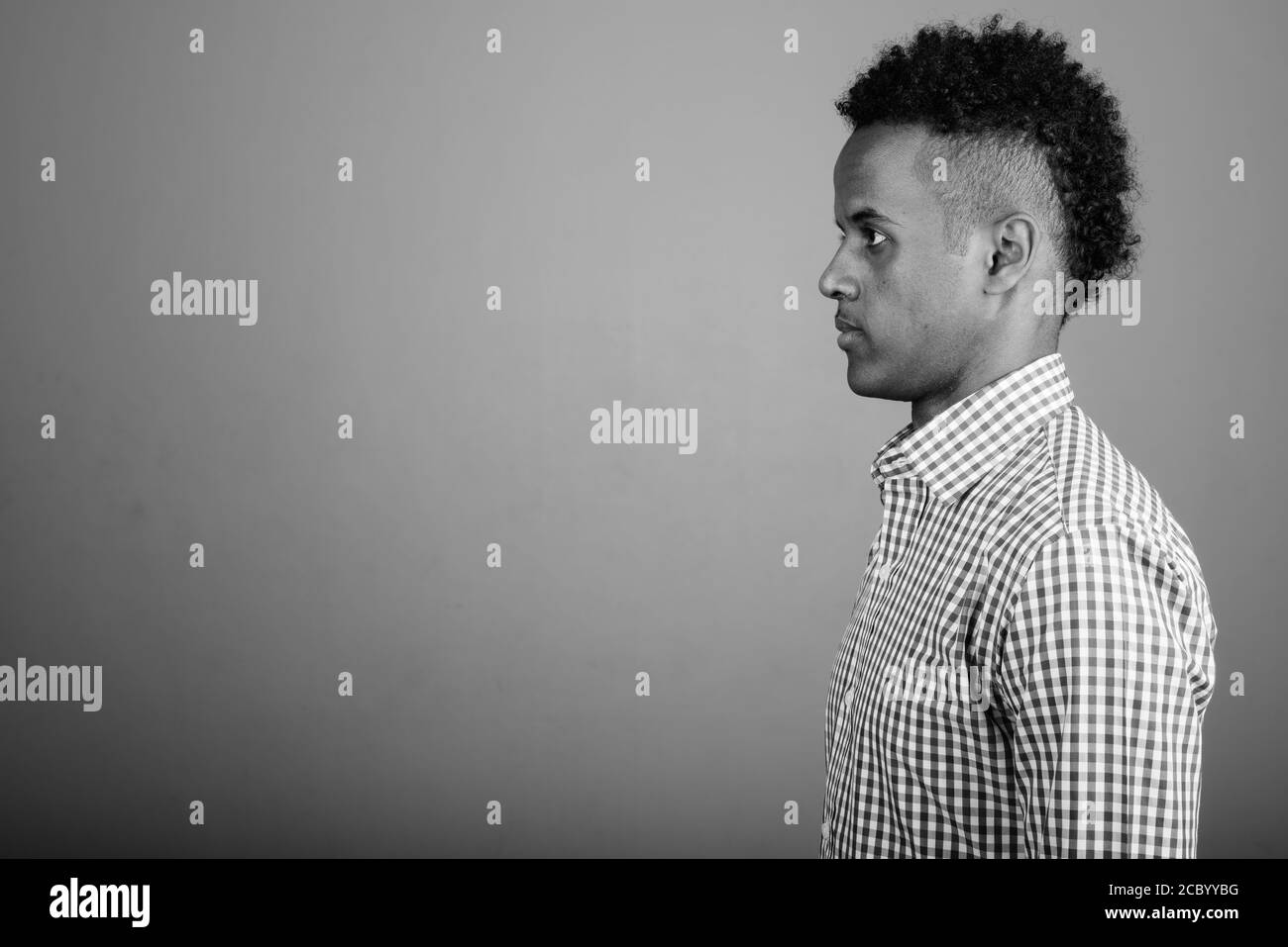 Beau jeune homme d'Afrique contre l'arrière-plan gris Banque D'Images