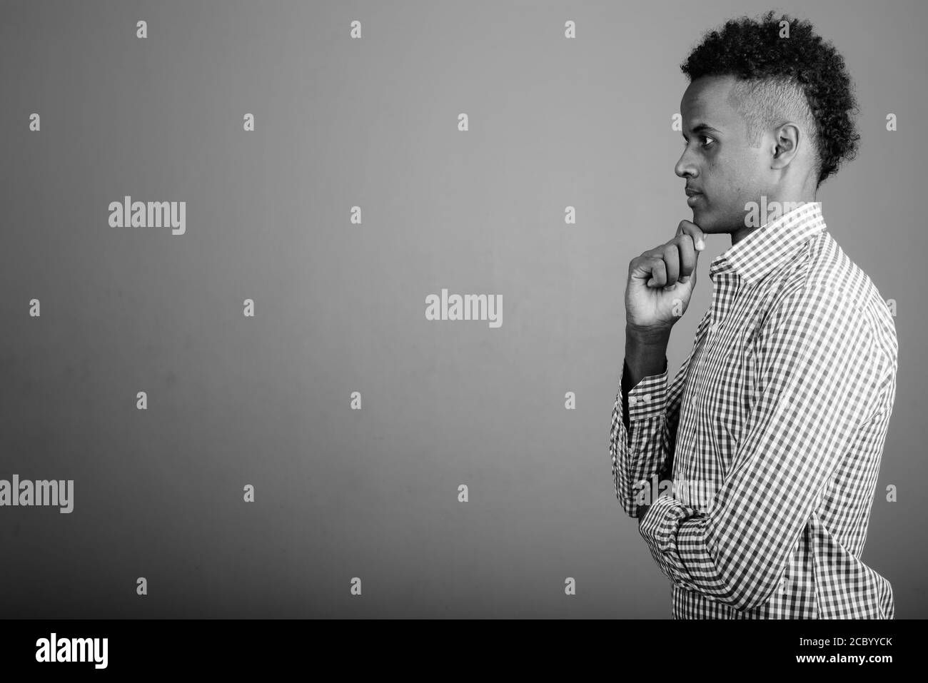 Beau jeune homme d'Afrique contre l'arrière-plan gris Banque D'Images