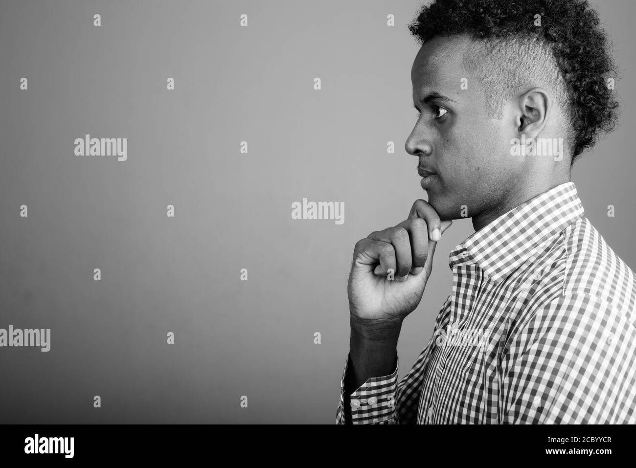 Beau jeune homme d'Afrique contre l'arrière-plan gris Banque D'Images