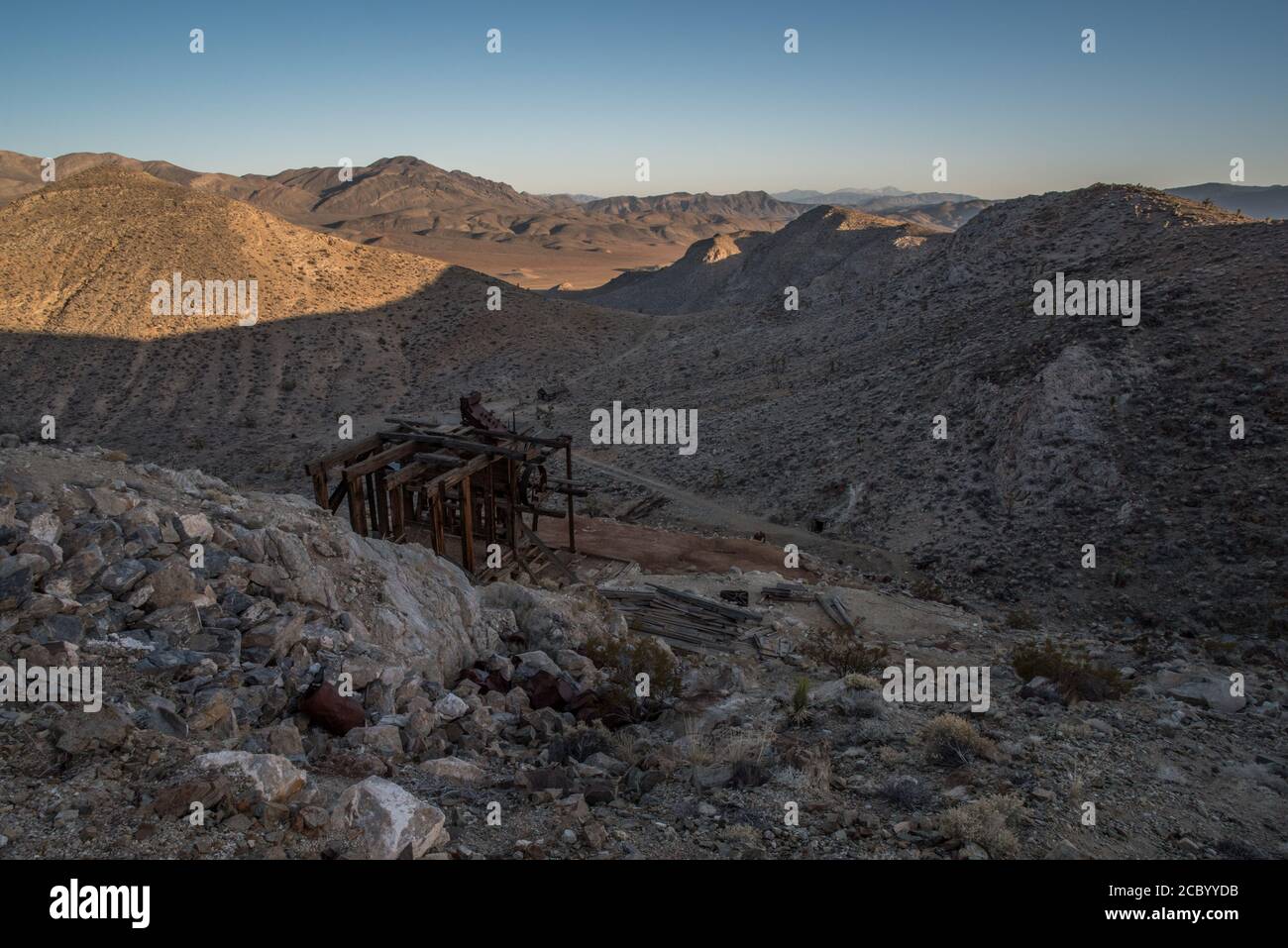 Un vieux bâtiment laissé par les mineurs il y a longtemps regarde sur les collines du parc national de la Vallée de la mort en Californie alors que le soleil se couche et que les ombres tombent. Banque D'Images