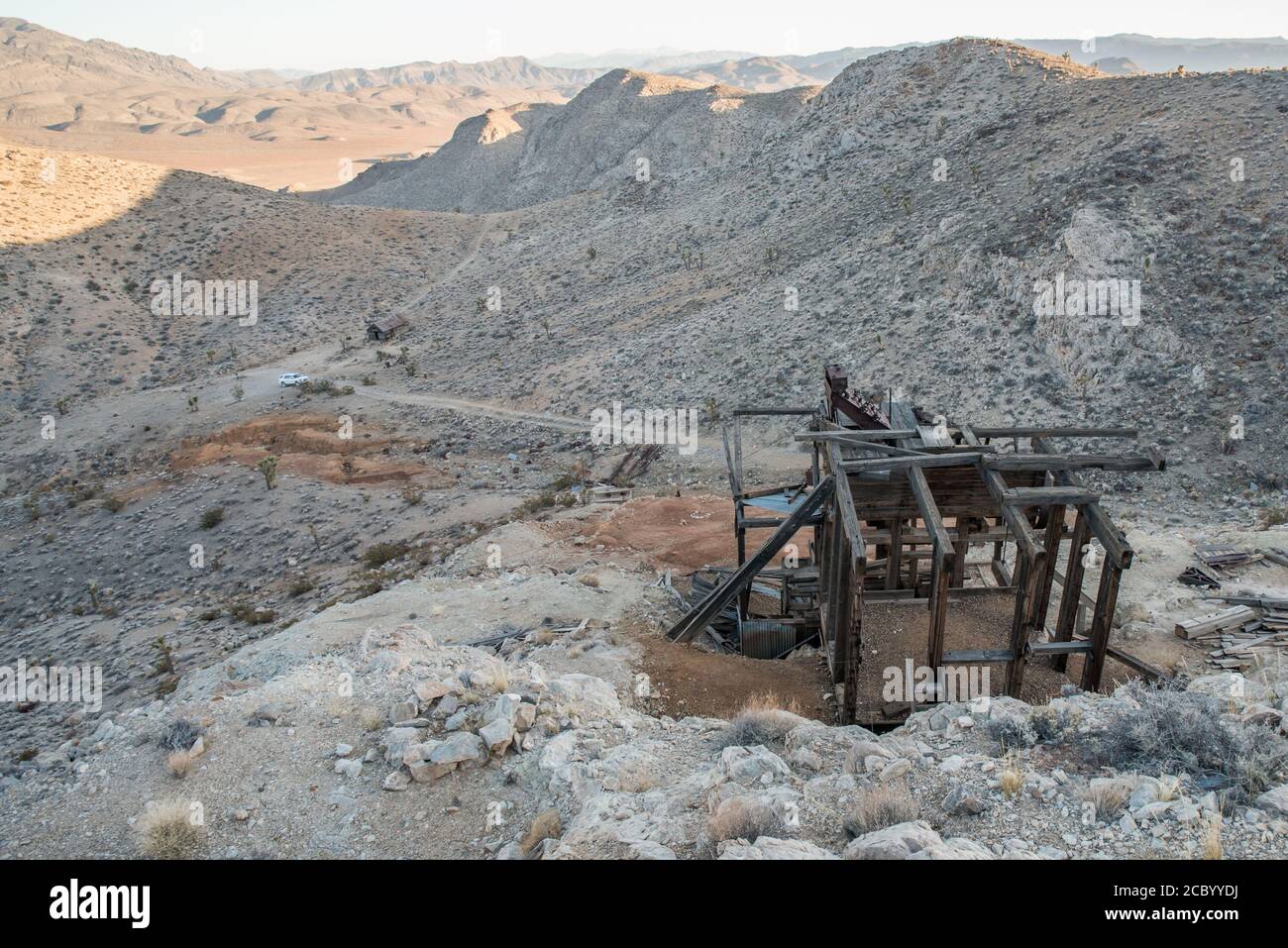 Un vieux bâtiment laissé par les mineurs il y a longtemps regarde sur les collines du parc national de la Vallée de la mort en Californie alors que le soleil se couche et que les ombres tombent. Banque D'Images