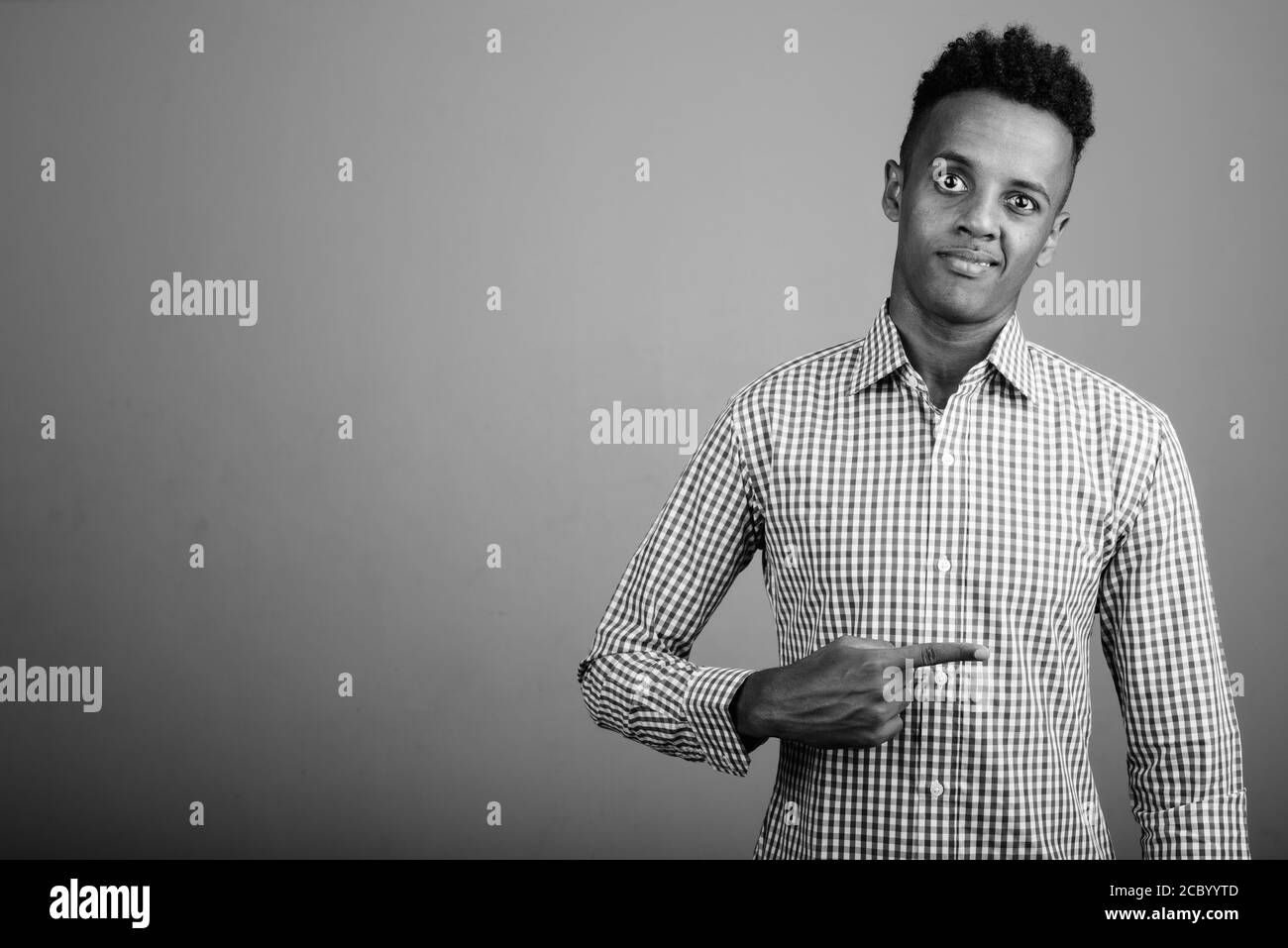 Beau jeune homme d'Afrique contre l'arrière-plan gris Banque D'Images