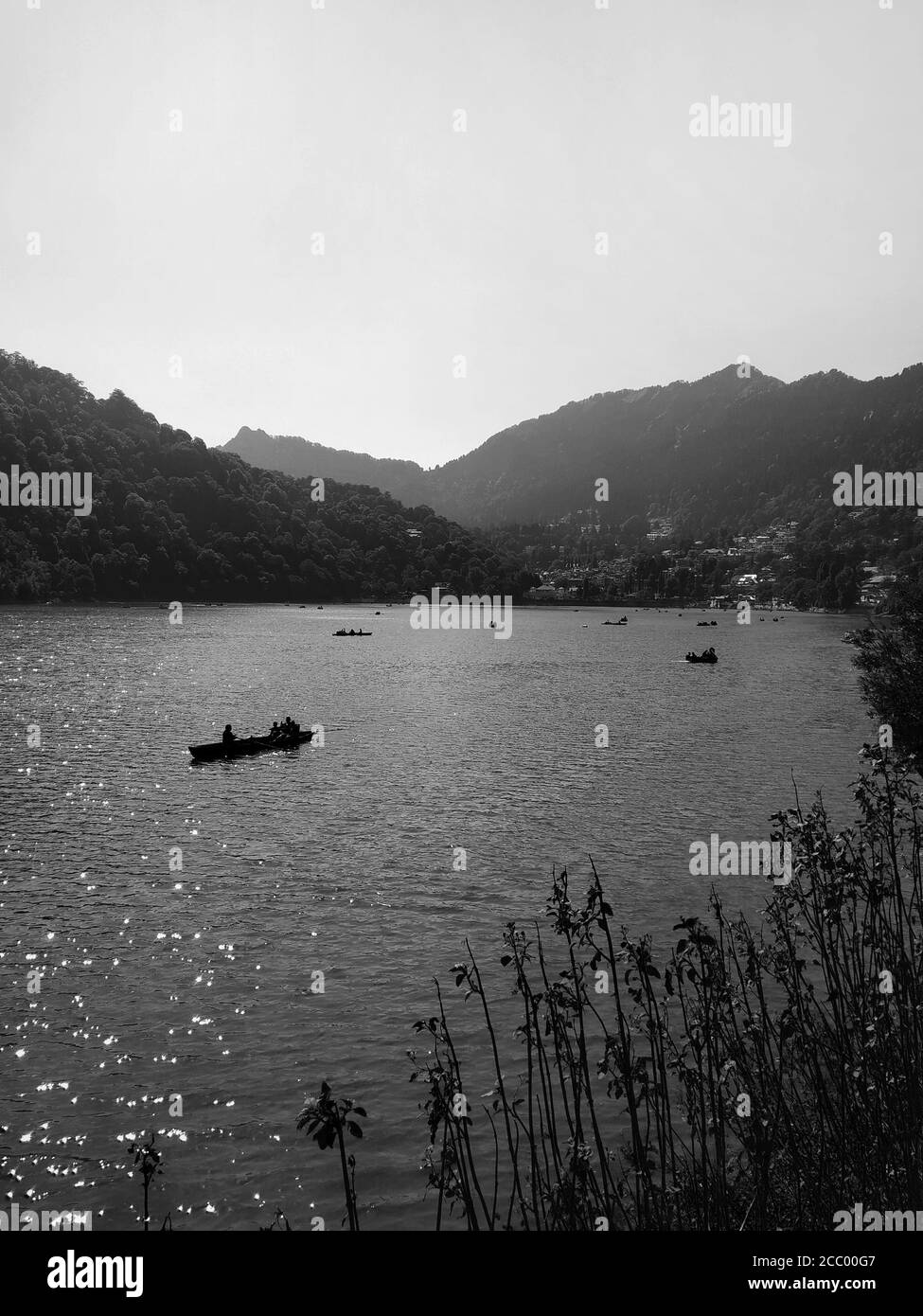 Photographie en noir et blanc du canotage sur un lac avec montagnes en arrière-plan Banque D'Images