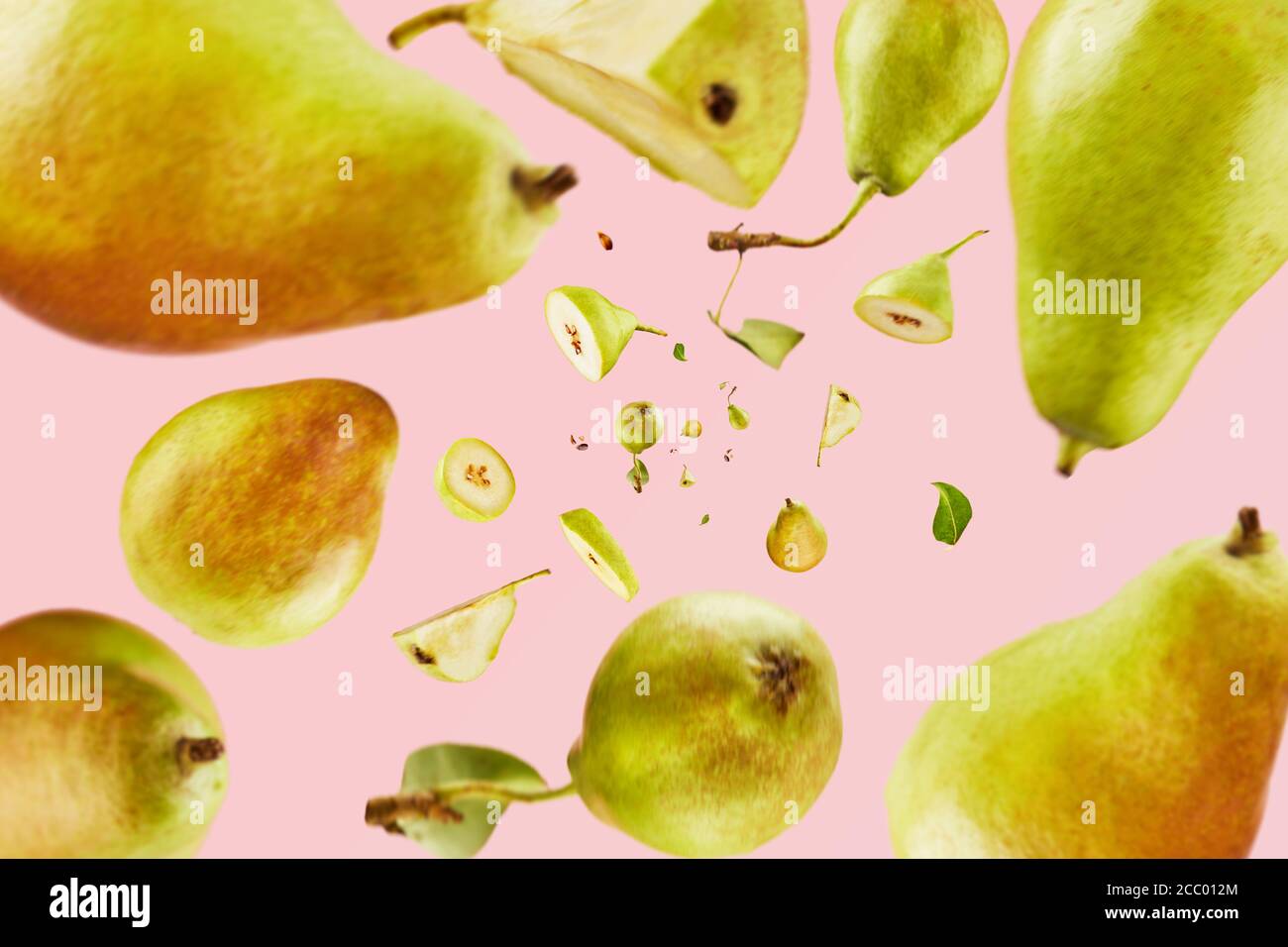 Poires fraîches tombant de haut en bas sur fond rose. Concept d'abondance de fruits. Répétition Banque D'Images