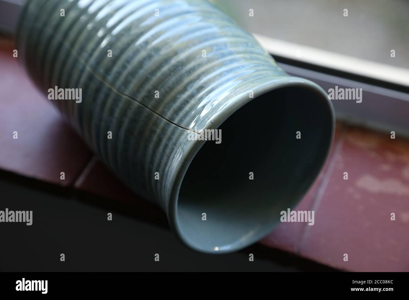 Photo d'un vase en argile tombé sur le sol avec une fissure Banque D'Images