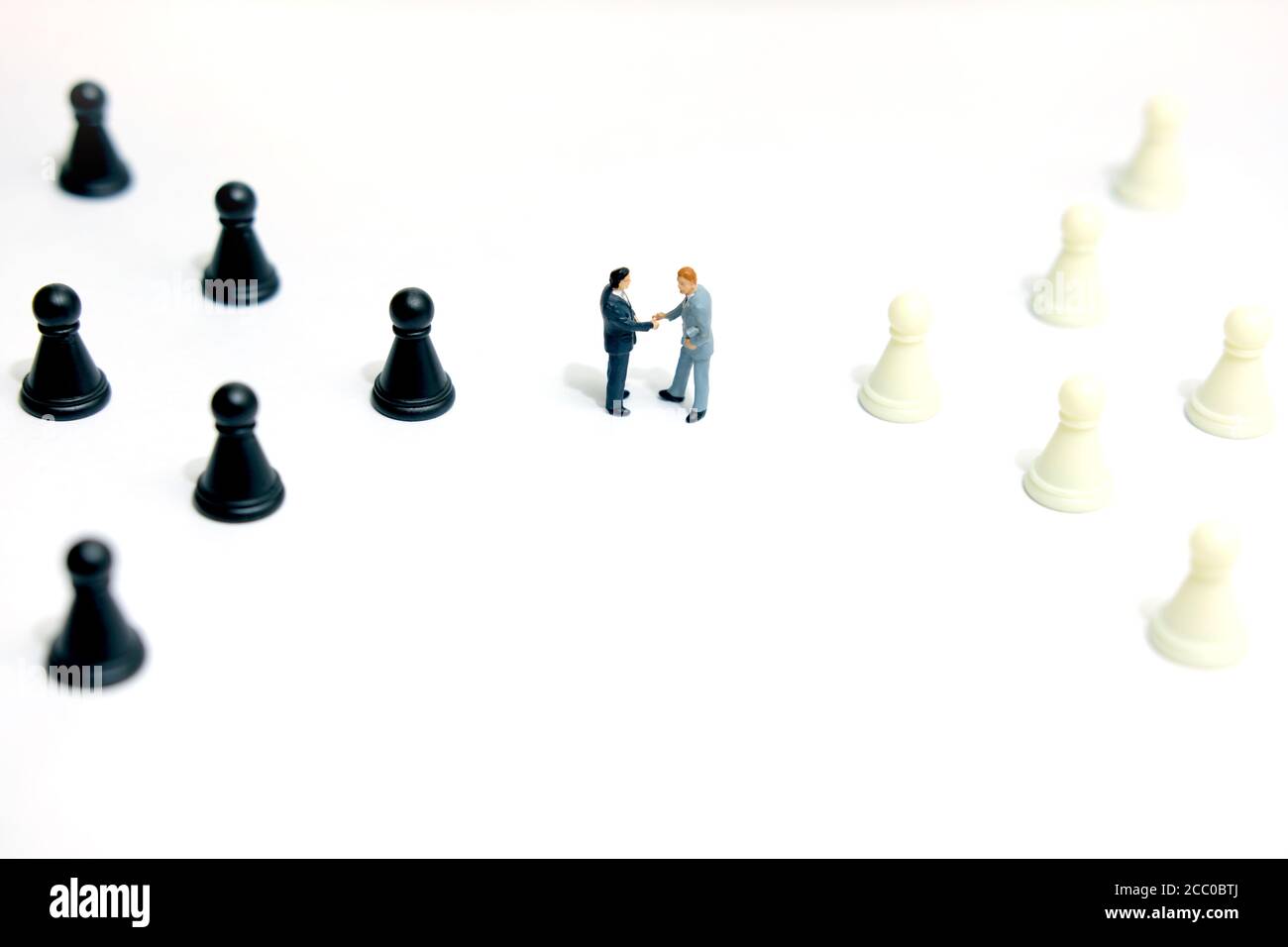 Concept d'affaires miniature - deux hommes d'affaires font un accord de poignée de main entre pion d'échecs Banque D'Images