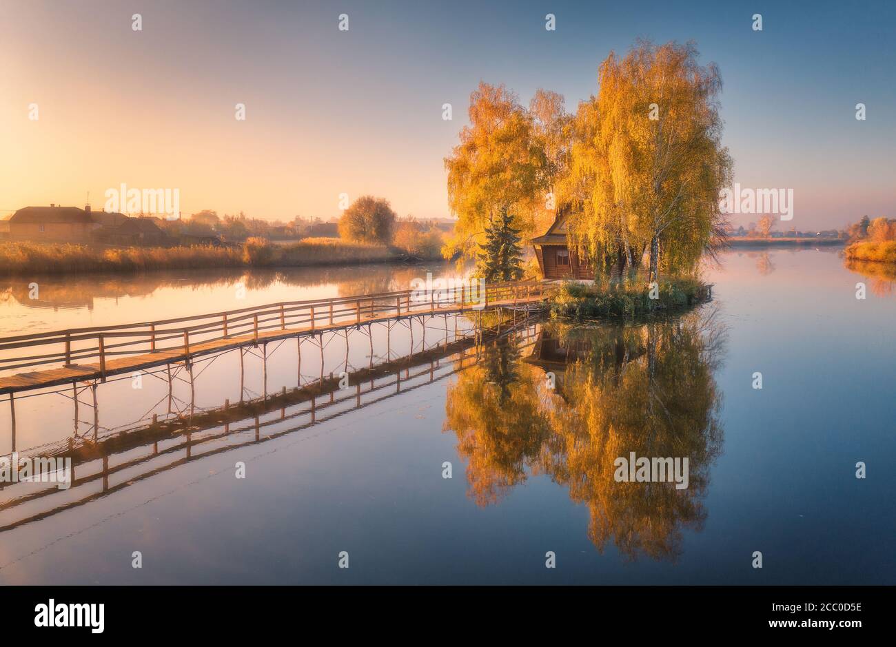 Ancienne maison de pêcheur et jetée en bois au lever du soleil en automne Banque D'Images