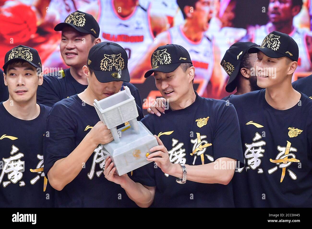 Les membres de Guangdong Southern Tigers, une équipe de basket-ball professionnelle chinoise appartenant au groupe Guangdong Winnerway (Hongyuan), célèbrent leur championnat après la finale dans la ville de Qingdao, province de Shandong en Chine orientale, le 15 août 2020. Les Tigres du Sud de Guangdong ont remporté le championnat CBA 2019-20 après avoir battu les Liaoning Flying Leopards 123-115 dans le jeu 3 des finales. Banque D'Images