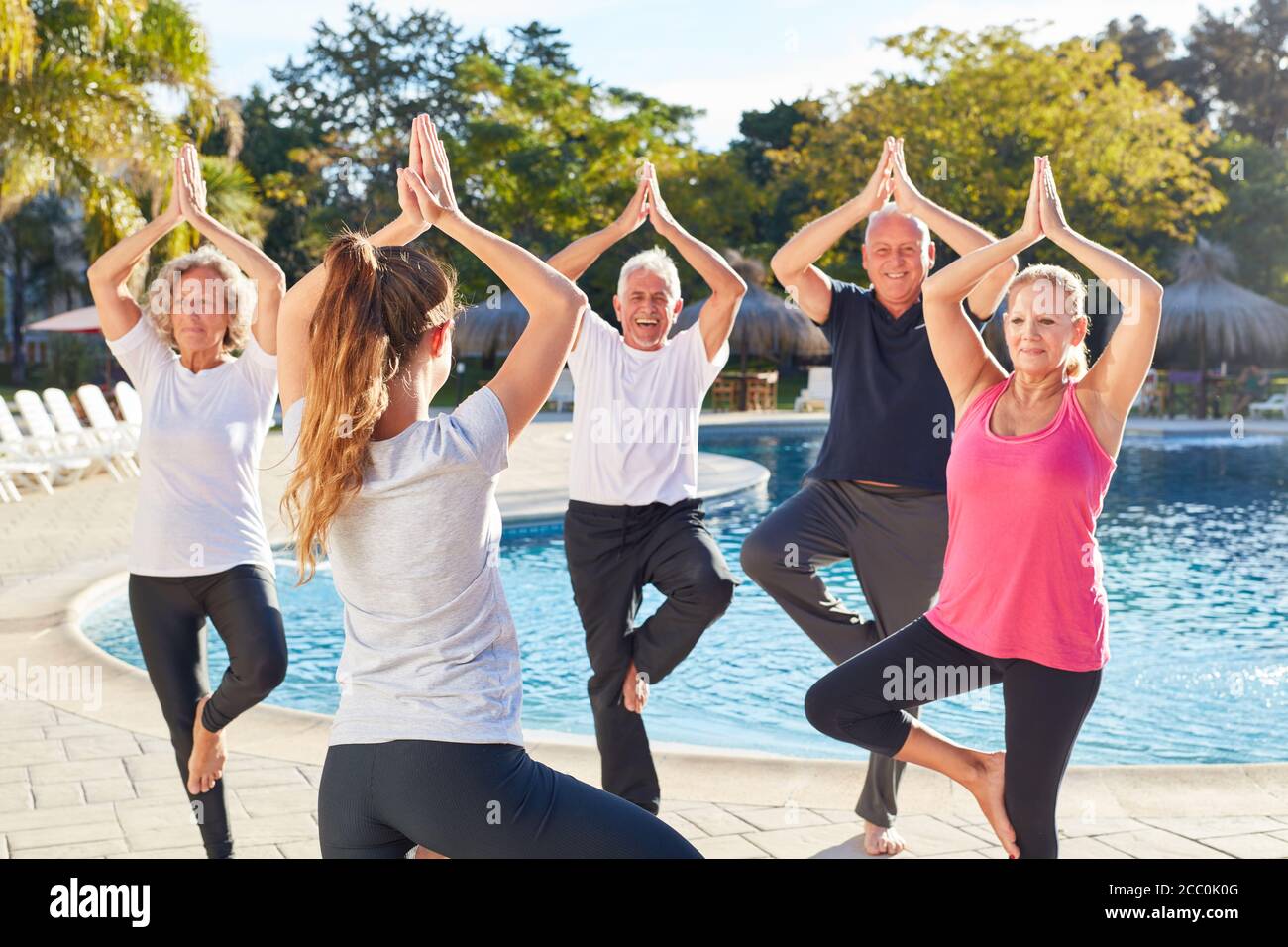 Regroupez les aînés en vacances dans le cours de yoga l'exercice vrksasana Banque D'Images