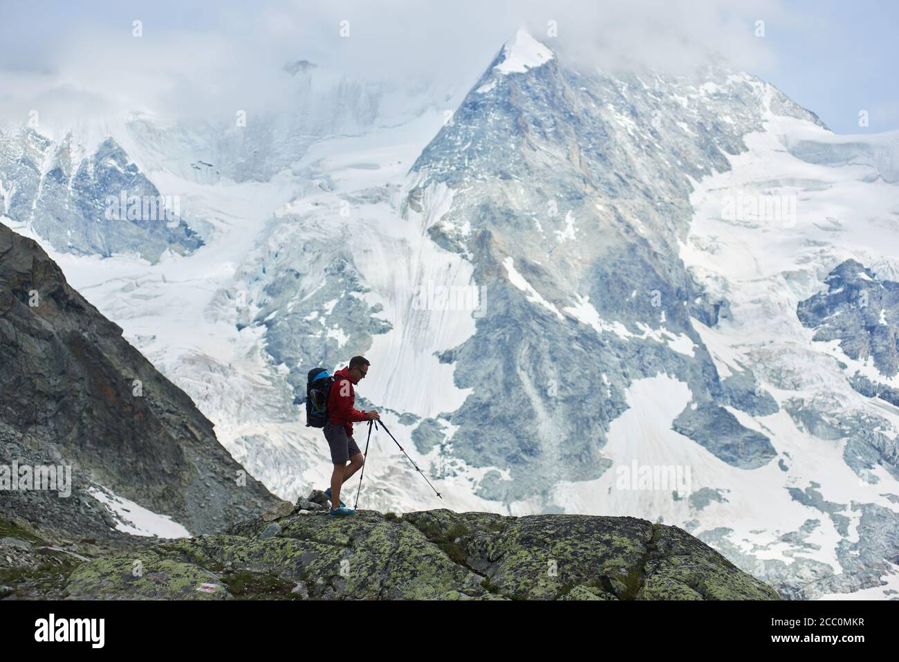 Photo horizontale de l'incroyable, rocailleux Mont Ober Gabelhorn dans la neige dans les Alpes de Pennine en Suisse, situé entre Zermatt et Zinal, voyageur marchant avec des bâtons de trekking au premier plan Banque D'Images