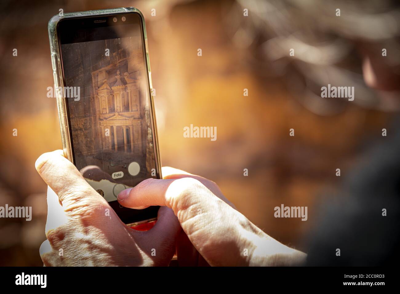PETRA, JORDANIE - 03 mars 2020: Petra, Jordanie, mars 2020: Touriste prendre une photo avec un smartphone, ou téléphone mobile du Trésor à partir du viewpoin Banque D'Images
