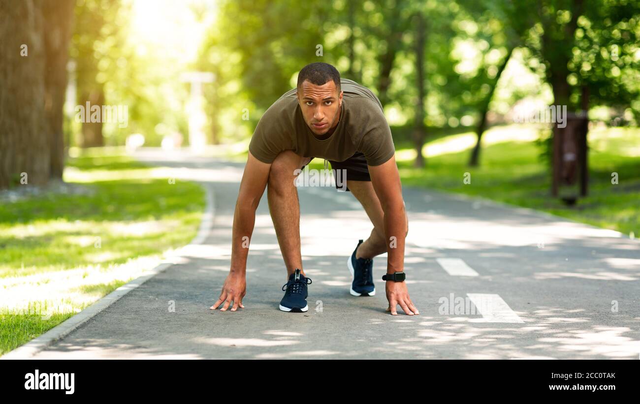 Coureur de marathon noir prêt à commencer la course sur piste de jogging au parc Banque D'Images
