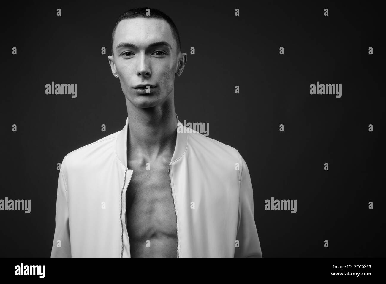 Jeune homme androgyne beau sur fond gris Banque D'Images