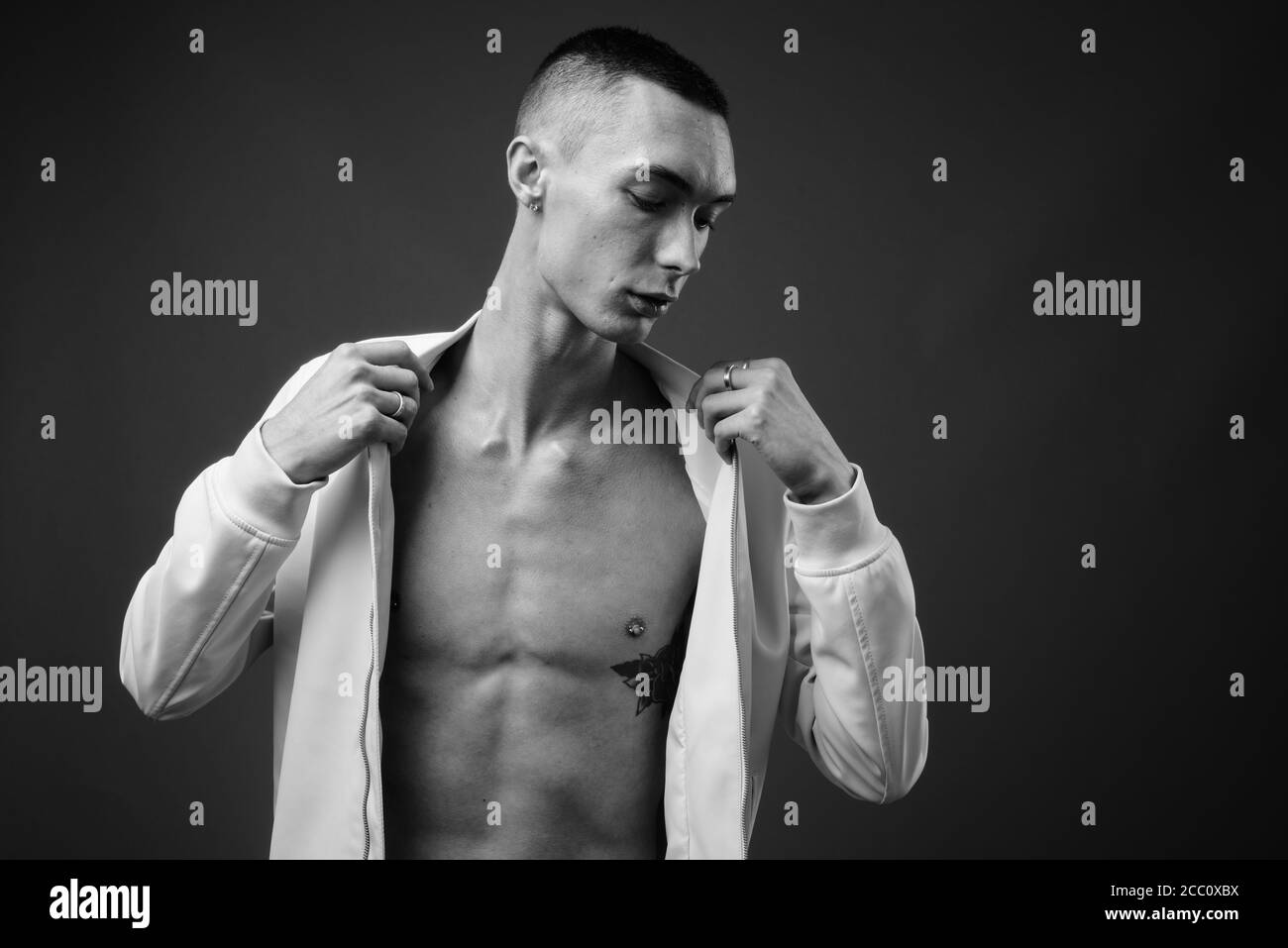 Jeune homme androgyne beau sur fond gris Banque D'Images