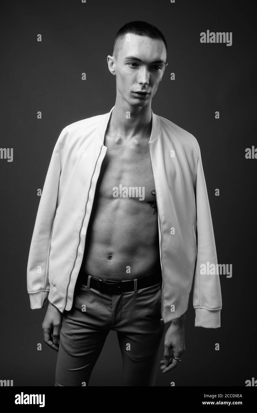 Jeune homme androgyne beau sur fond gris Banque D'Images