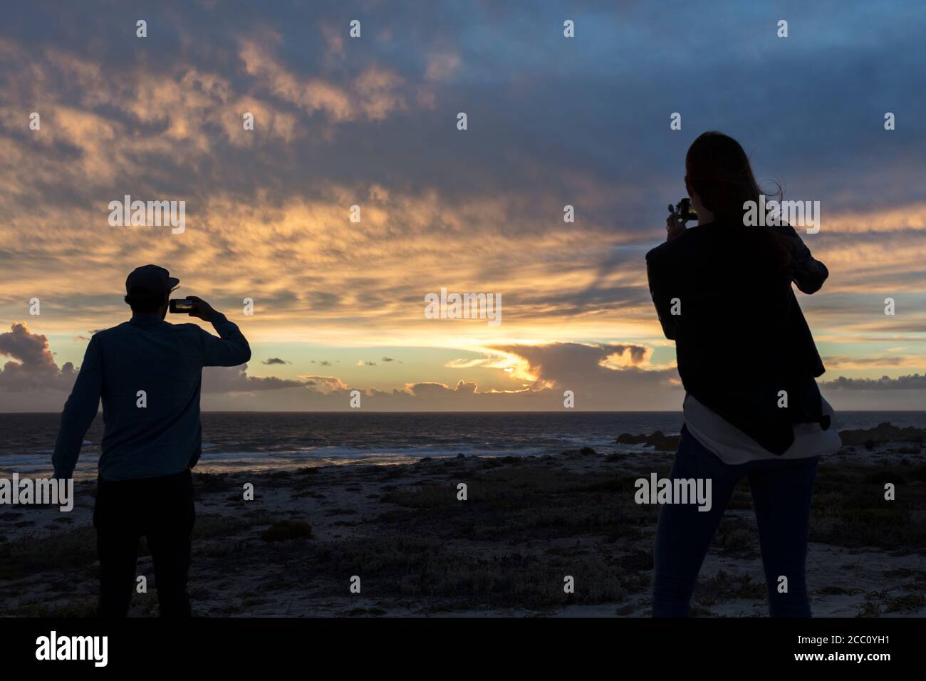 Jeune couple prenant des photos de magnifique coucher de soleil Banque D'Images