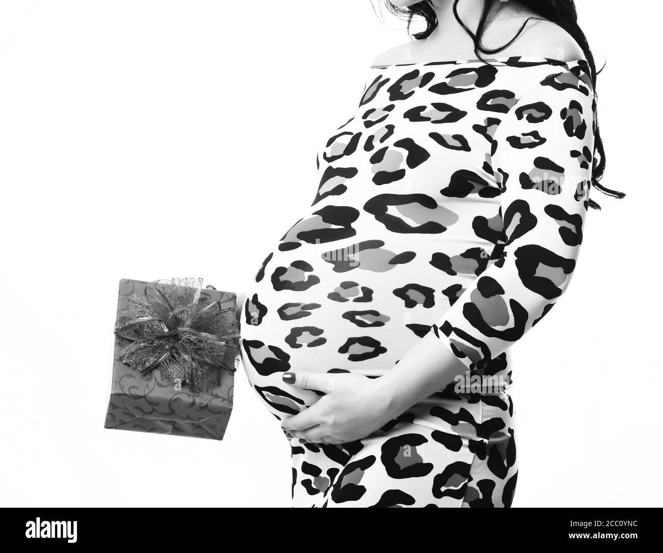 mains féminines de la femme enceinte tenant rouge présent ou cadeau dans une robe colorée à imprimé léopard isolée sur fond blanc studio, espace de copie Banque D'Images