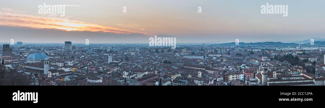 Les gratte-ciel de la ville qui s'étendent sous Colle Cidneo au coucher du soleil mettent en évidence le problème de l'espace de logement, la croissance humaine et la surpopulation - Brescia, Italie Banque D'Images