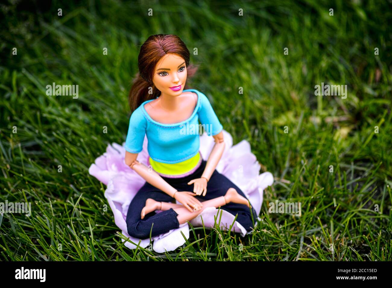 Tambov, Fédération de Russie - 12 juin 2020 Brunette Barbie poupée assis  dans la posture de yoga lotus sur l'herbe dehors Photo Stock - Alamy