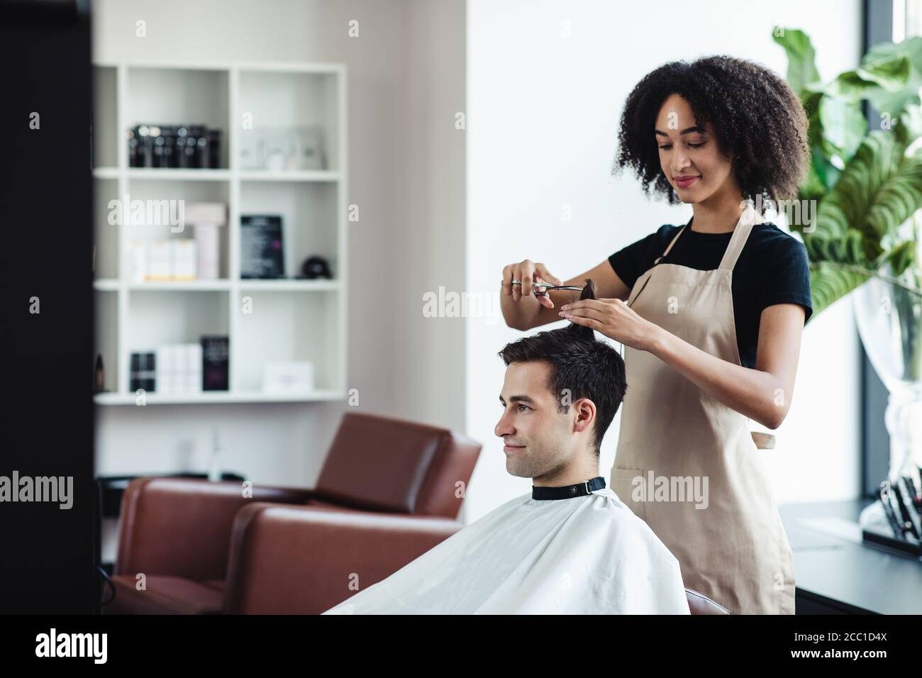 Un gars gai qui obtient une nouvelle coupe de cheveux aux coiffeurs, espace vide Banque D'Images
