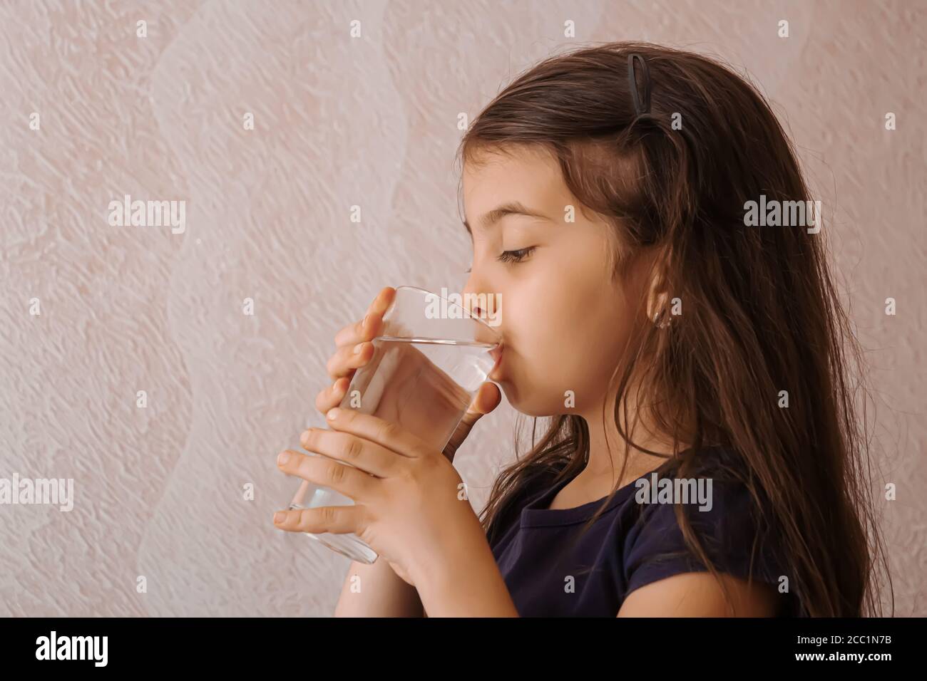 l'enfant tient un verre d'eau dans ses mains. foyer sélectif. Banque D'Images
