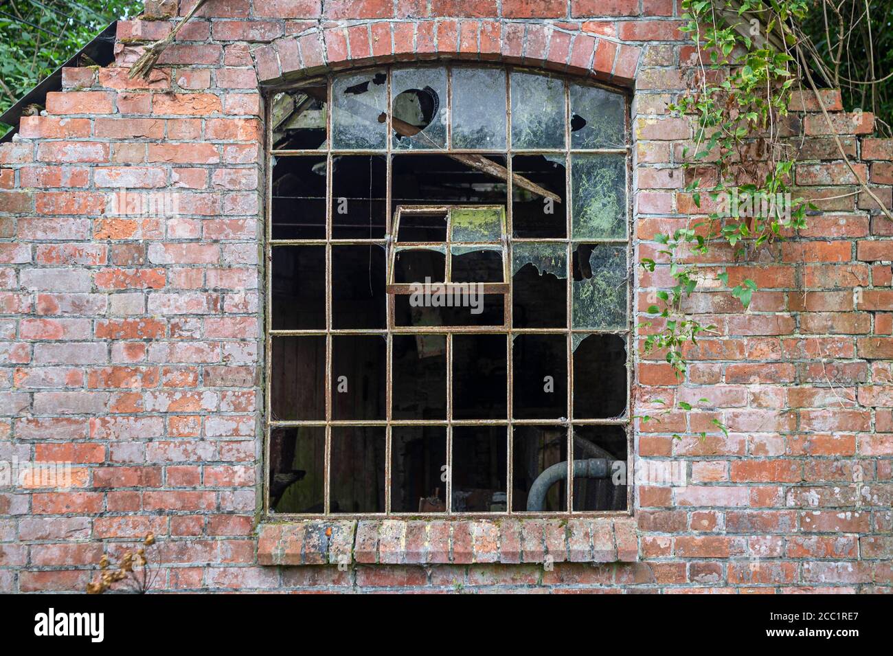 Fenêtres cassées dans un bâtiment industriel abandonné. Partie d'un bâtiment abandonné avec fenêtre cassée. Banque D'Images