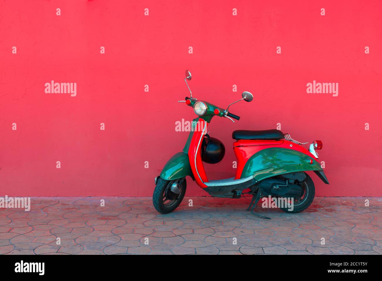 Parking électrique vert pour scooter sur fond de mur rose solide sur une rue de la ville. Concept de partage de voiture Banque D'Images