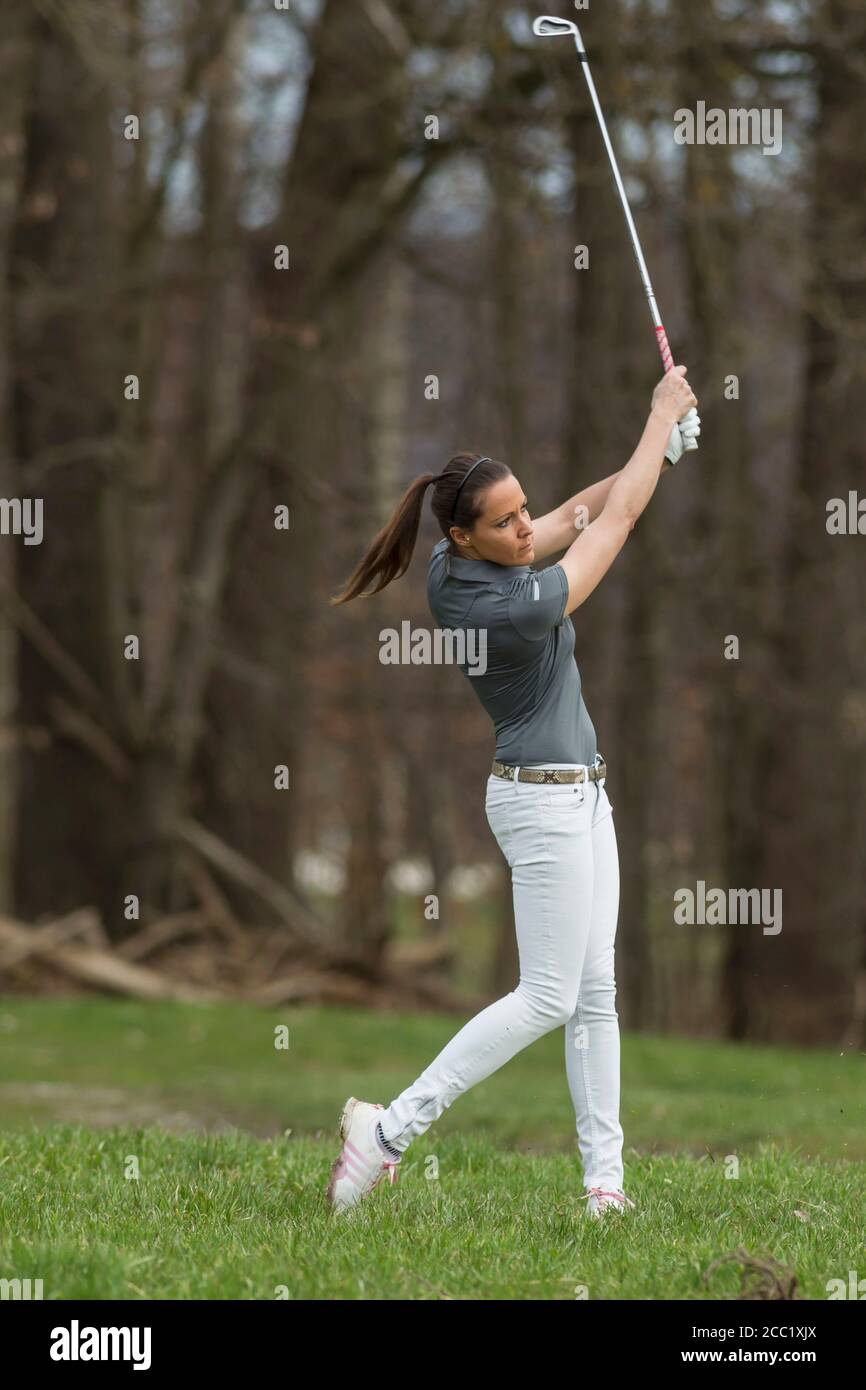 Germany, Bavaria, young woman playing golf Banque D'Images