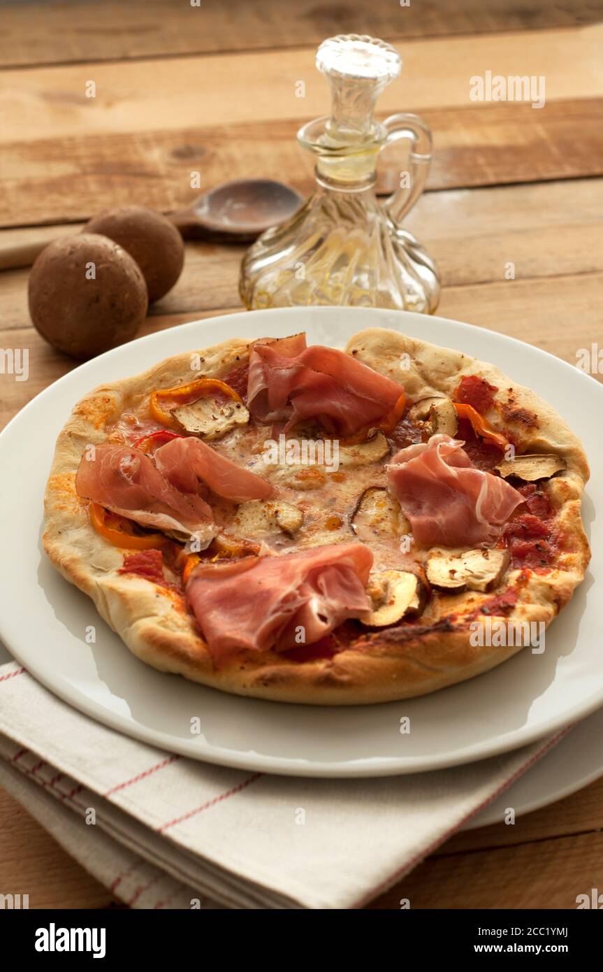 Assiette de pizza avec du jambon, des champignons et de la mozzarella sur table, Close up Banque D'Images
