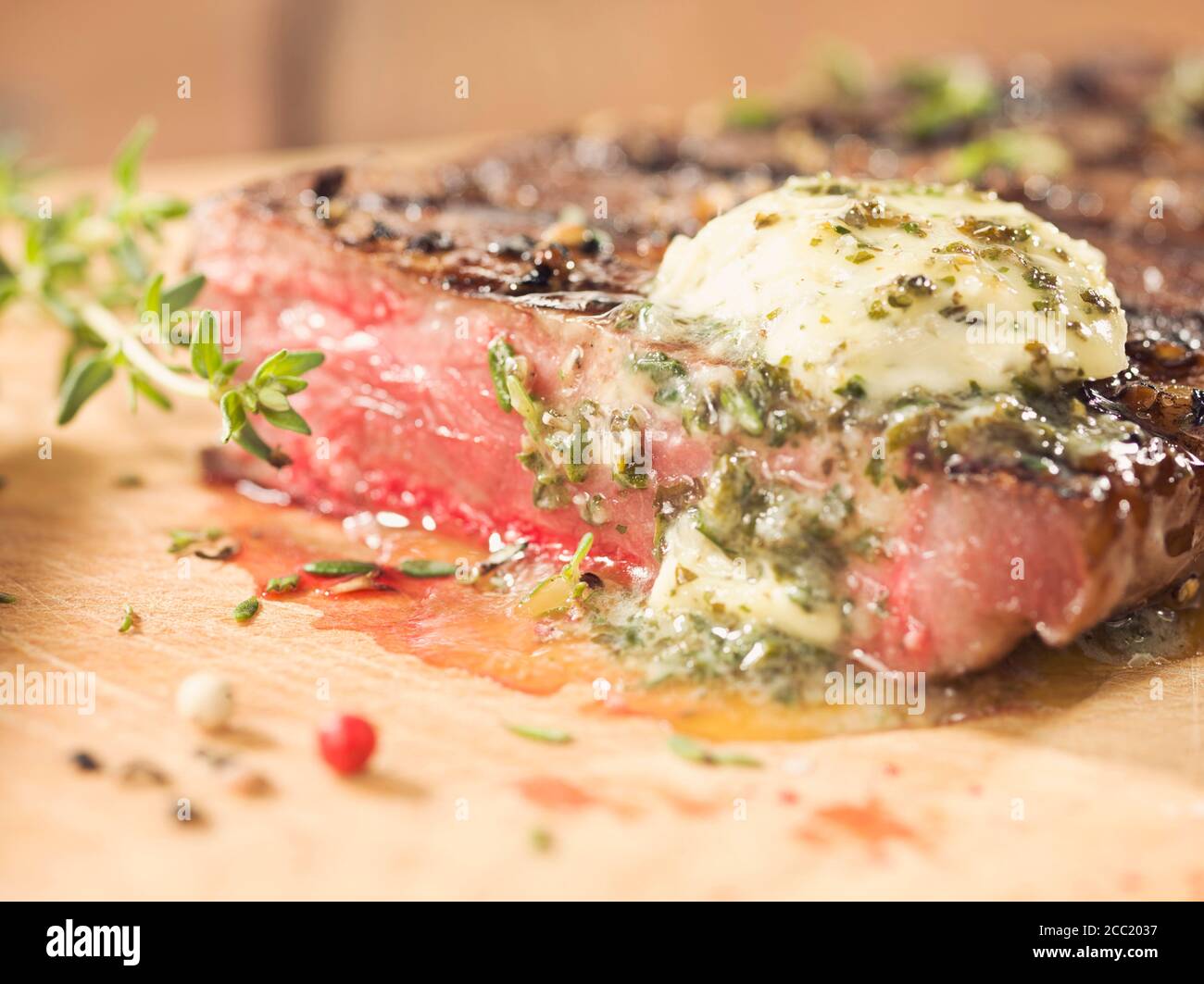 Pavé de rumsteak au beurre d'herbes sur bois Banque D'Images