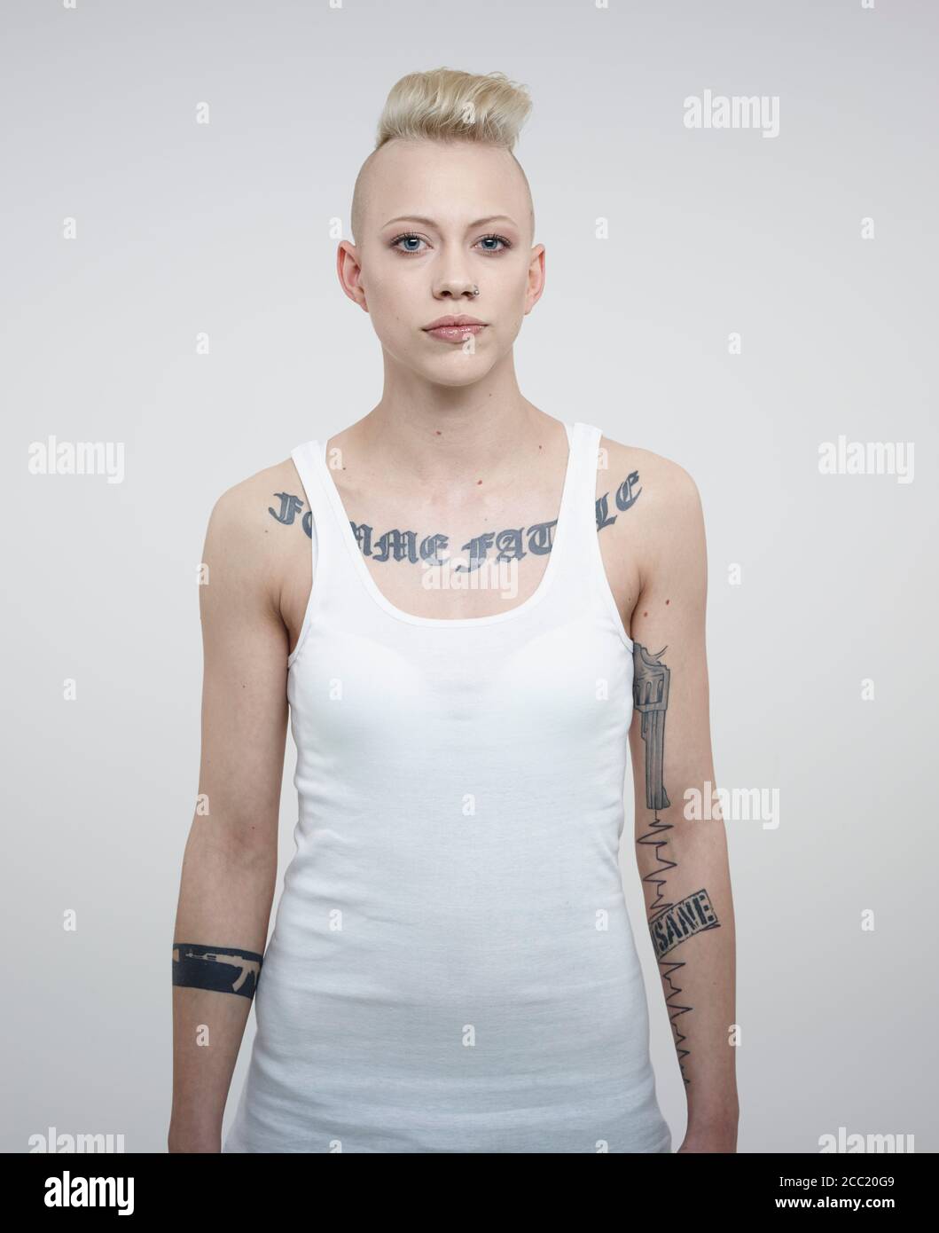 Portrait de jeune femme avec des tatouages against white background Banque D'Images