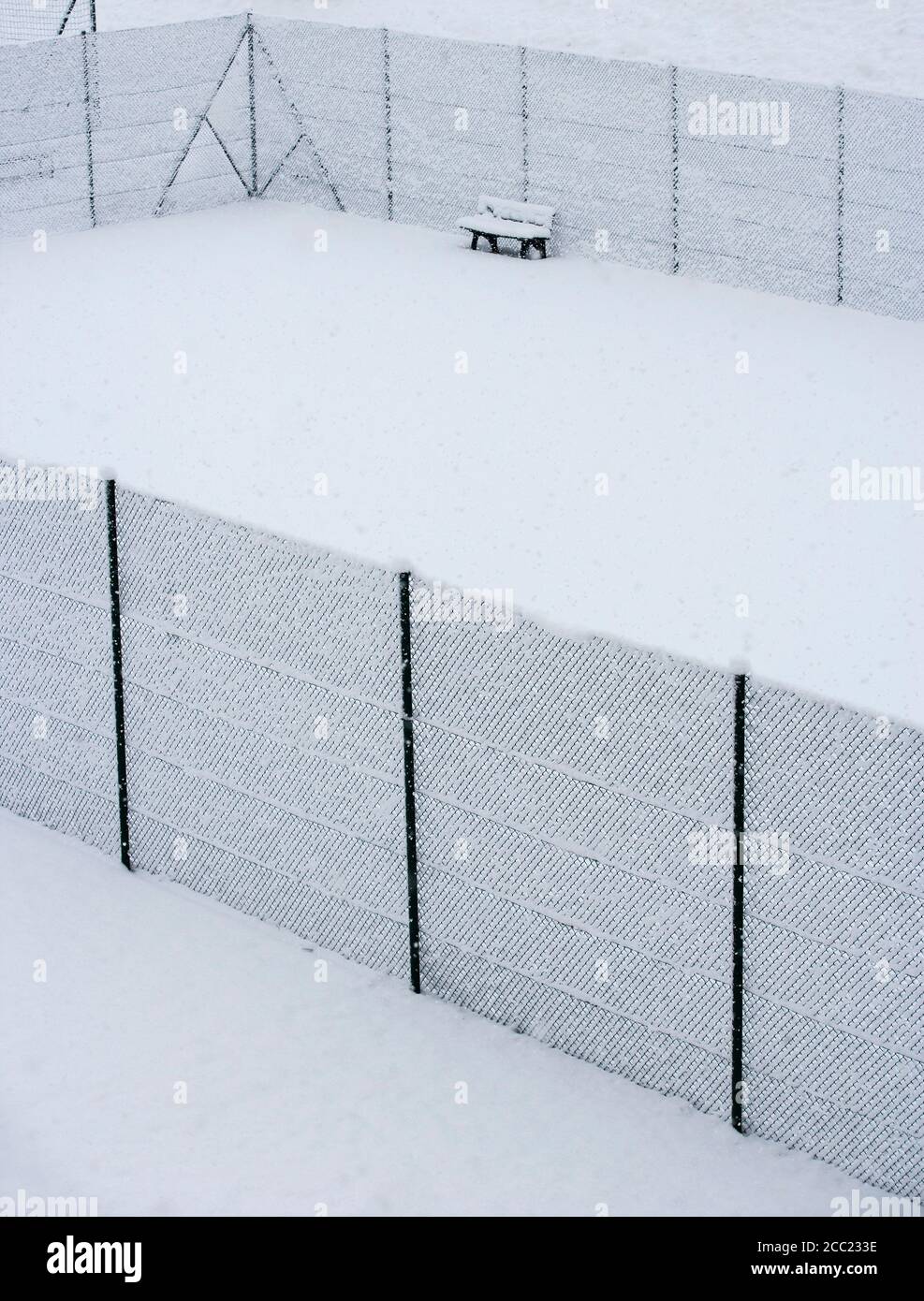 L'Autriche, Styrie, banc et clôture couverte de neige à court de tennis Banque D'Images