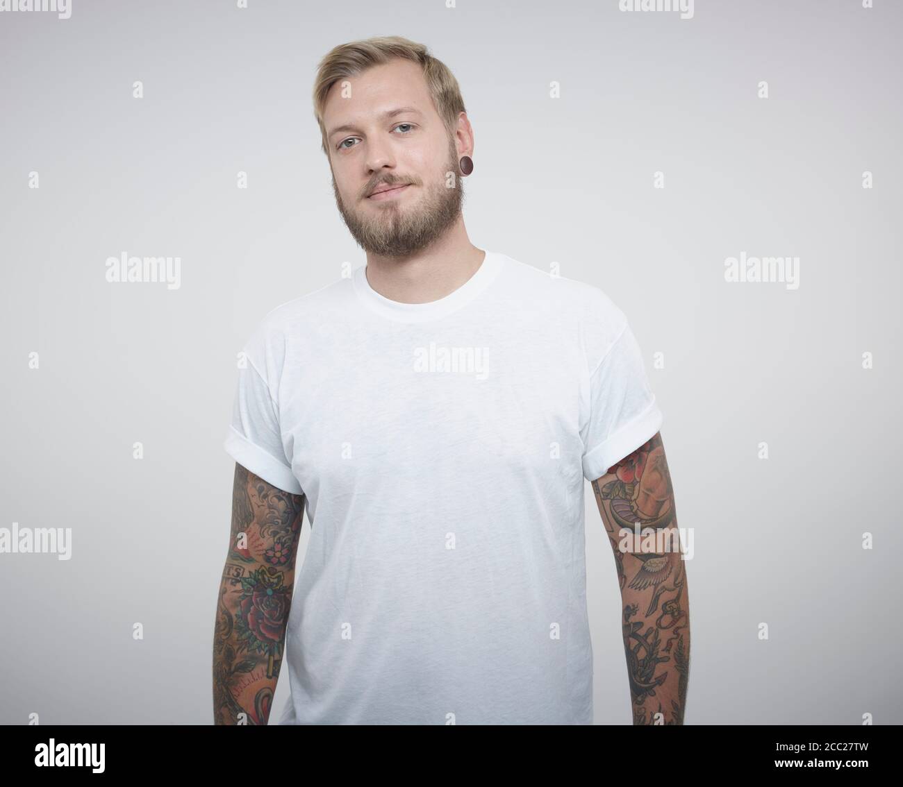 Portrait of young man with tattoos against white background Banque D'Images