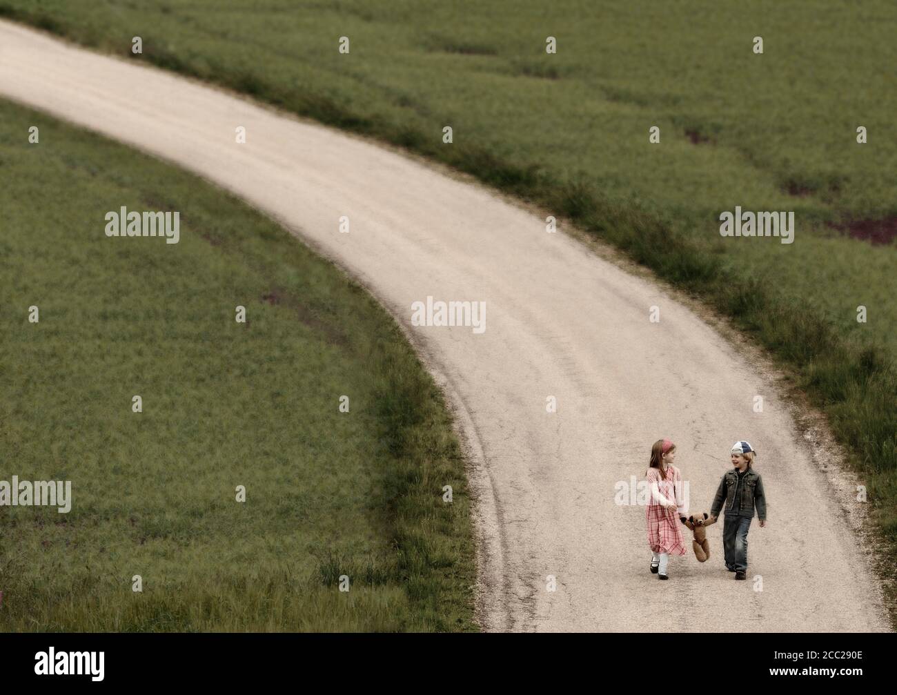 Autriche, fille et garçon marche sur route avec ours Banque D'Images
