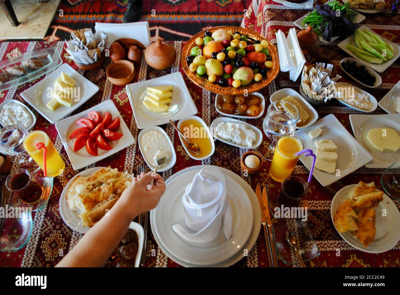 Petit-déjeuner turc avec une variété de fruits frais, fromage, yaourt, miel, confiture, jus de fruits, pâtisseries et thé sur une table de restaurant à Gebele Azerbaïdjan. Banque D'Images