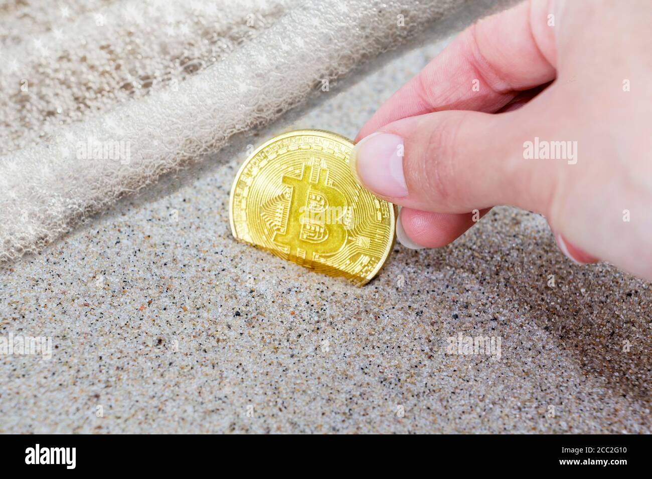 le bitcoin de pièce est enterré dans le sable et près de la vague de la mer. Bitcoin est la crypto-monnaie la plus populaire au monde. Banque D'Images