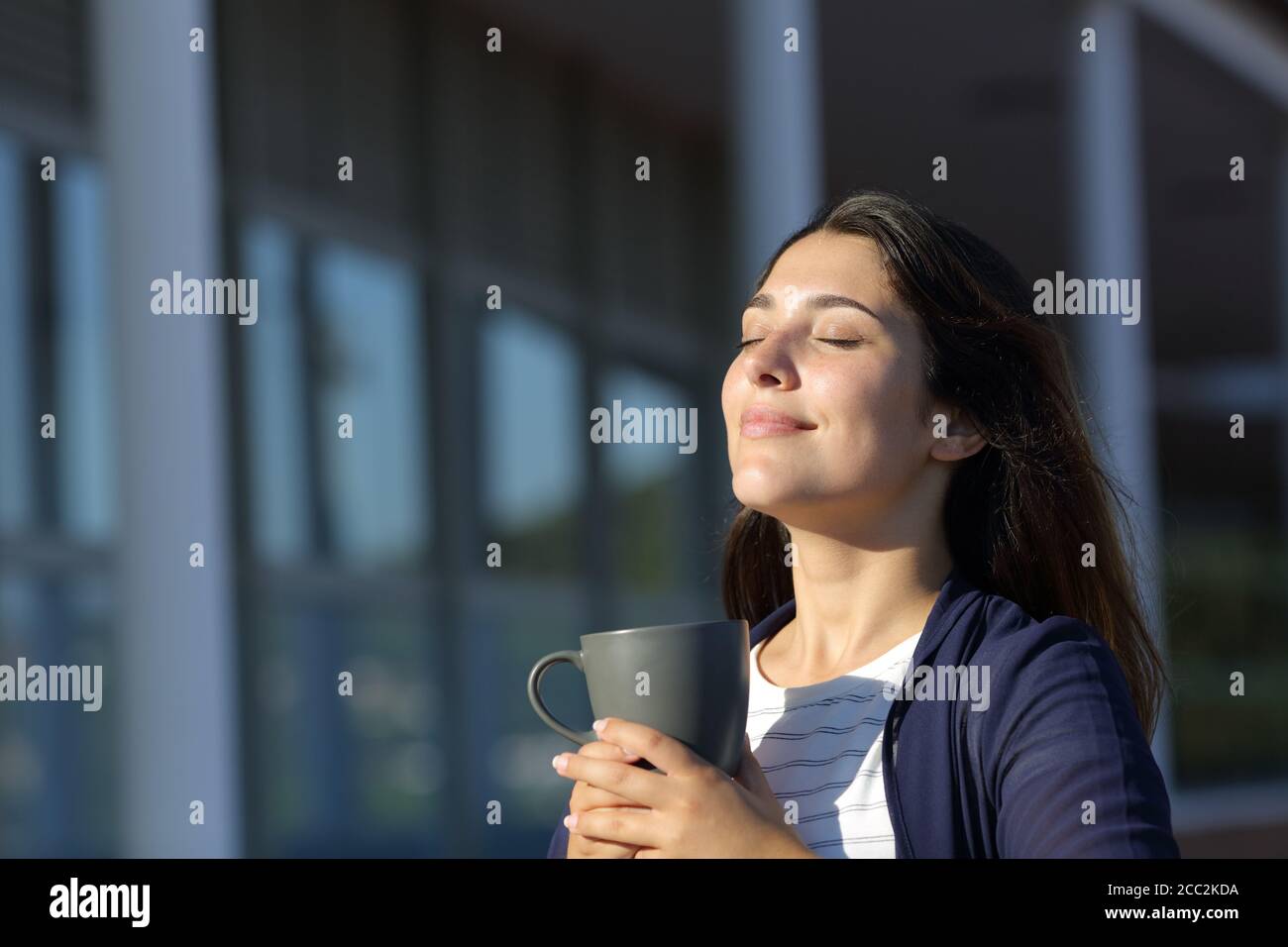 Femme se détendant boire du café et respirer de l'air frais dans un hôtel Banque D'Images
