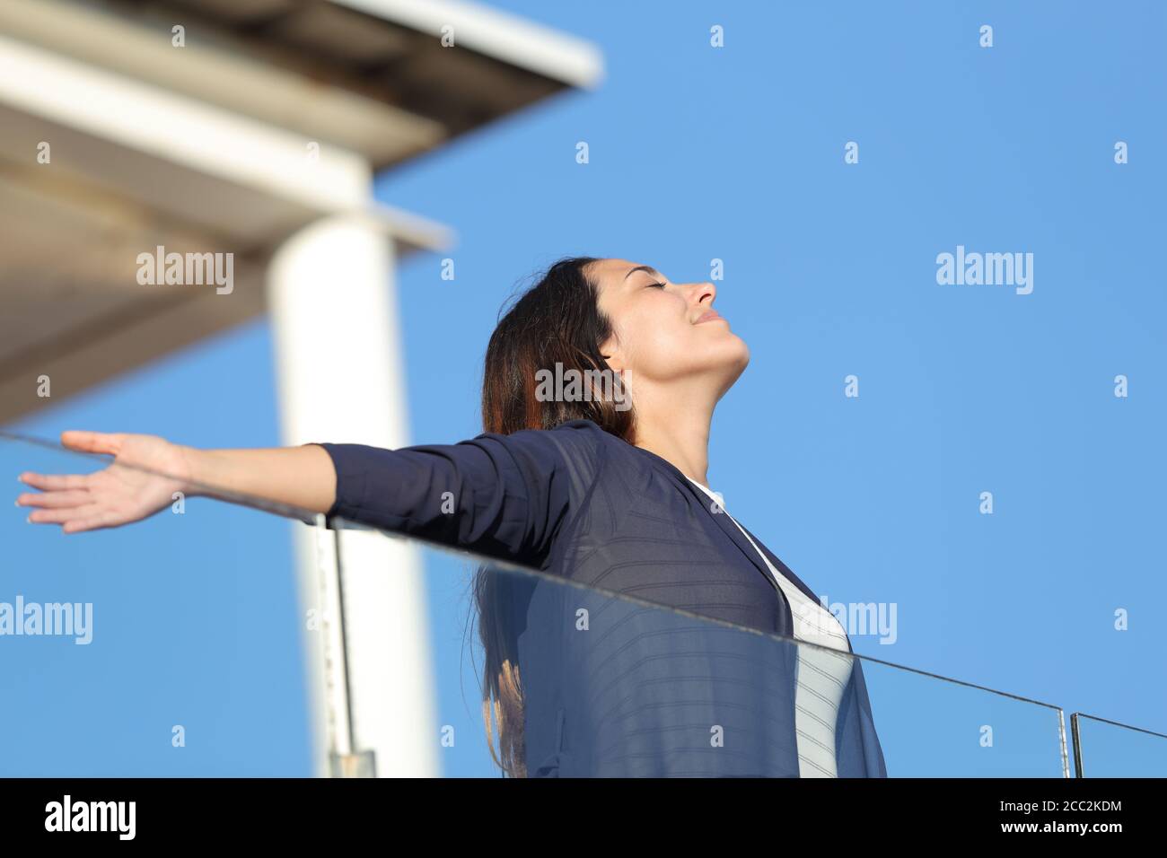 La femme rentreuse respirait de l'air frais dans un balcon d'appartement vacances d'été Banque D'Images