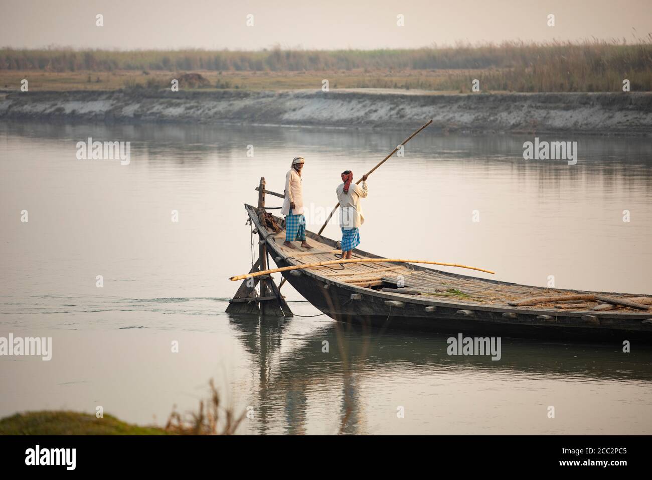 Un traversier rempli de travailleurs migrants traverse la rivière Gandak, qui forme la frontière nord de l'Inde avec le Népal. Banque D'Images