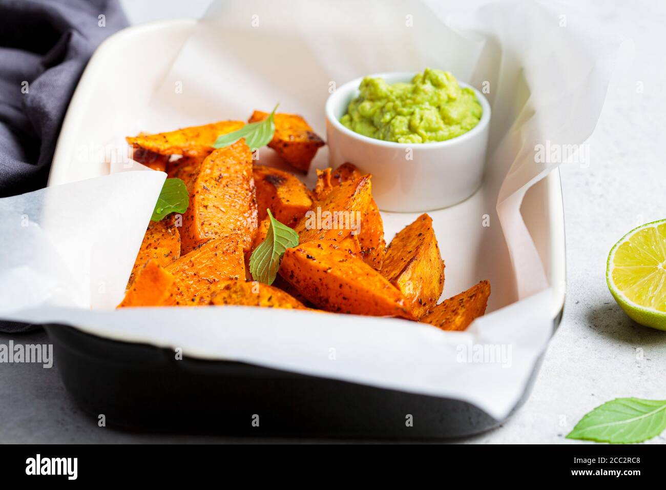 Quartiers de patates douces cuits avec sauce à l'avocat. Concept alimentaire végétalien sain. Banque D'Images