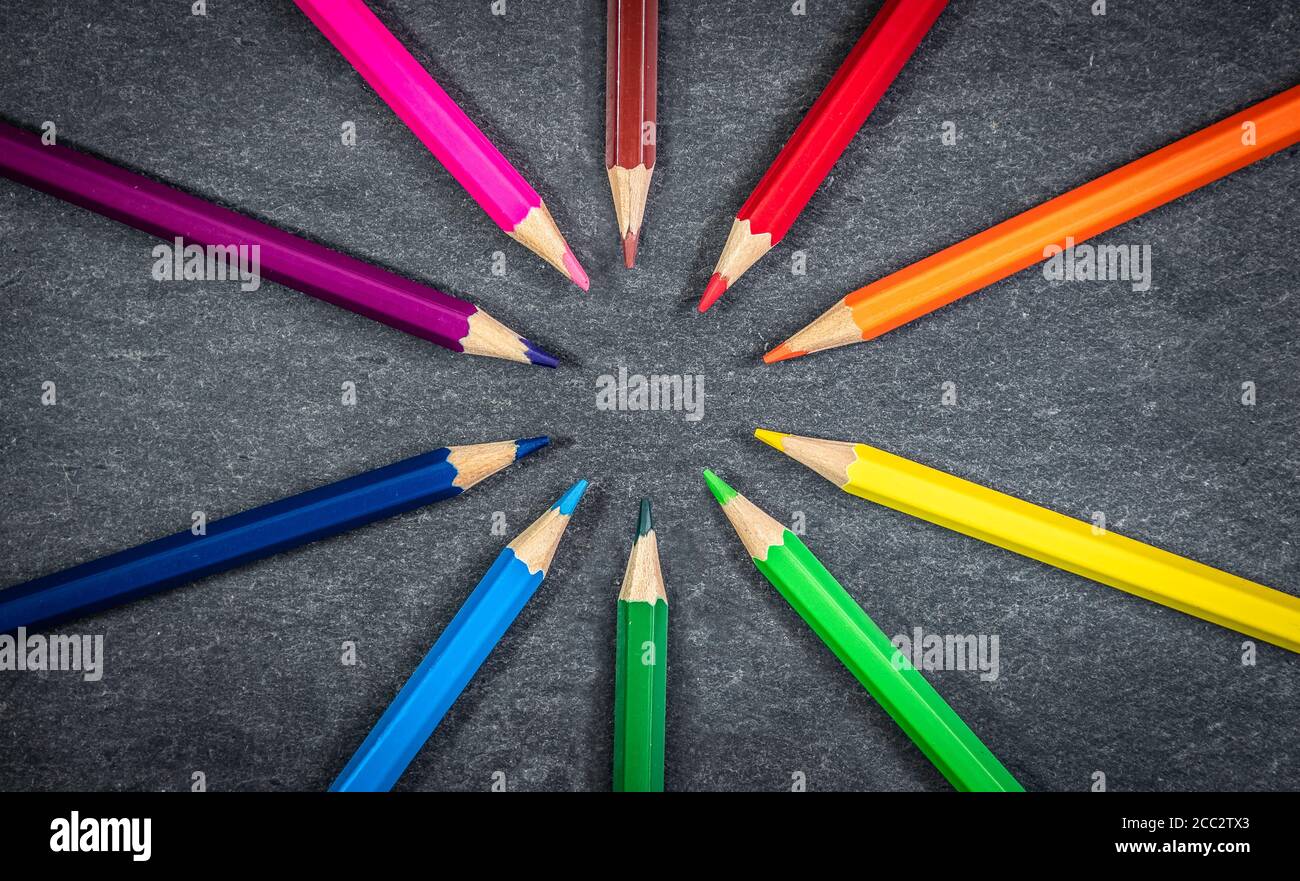 Crayons de couleur en cercle sur fond de texture ardoise. Banque D'Images