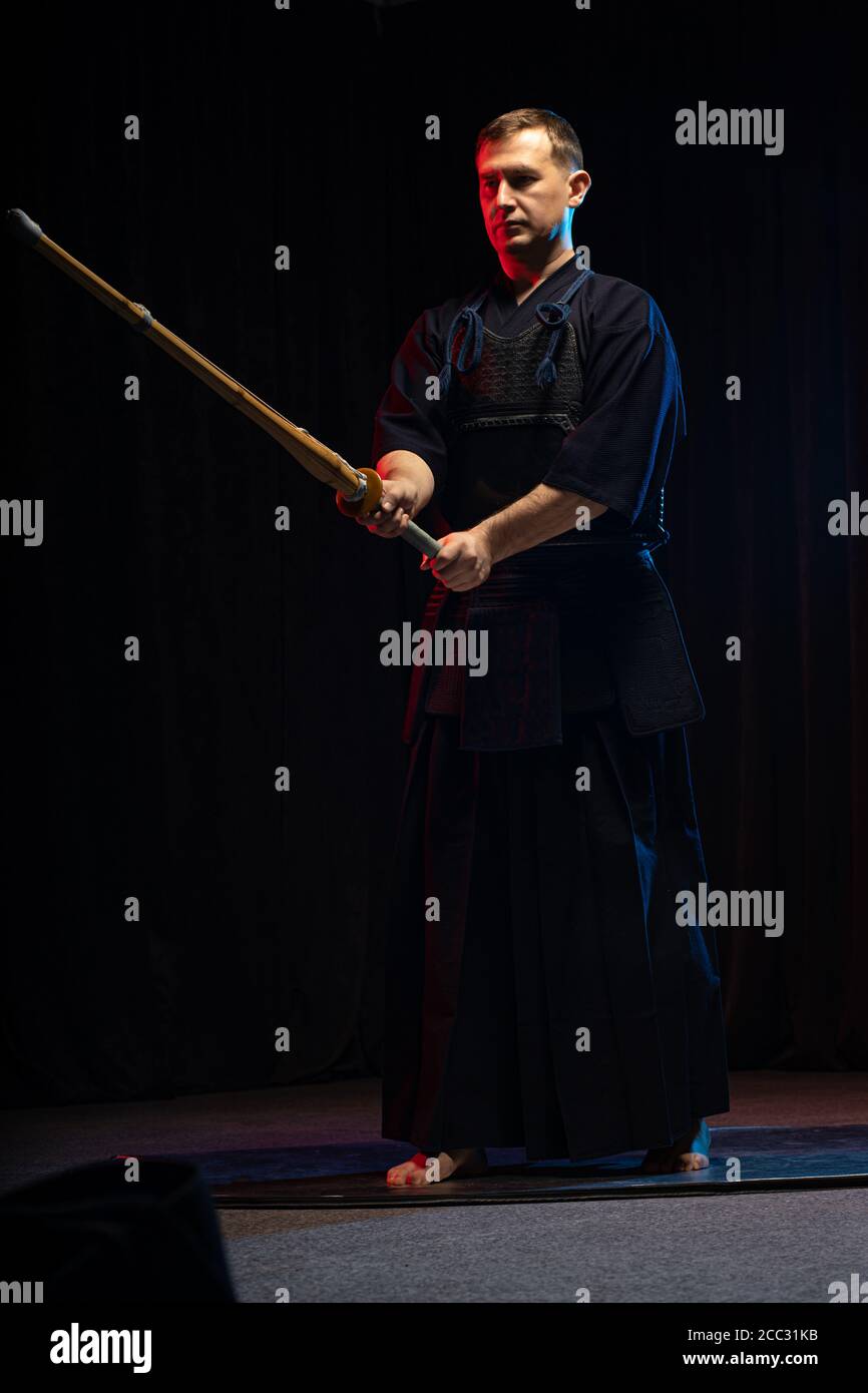 portrait d'un homme caucasien fort kendo combattant avec bokuto. kendo guerrier mâle tenant sabre samouraï katana Banque D'Images