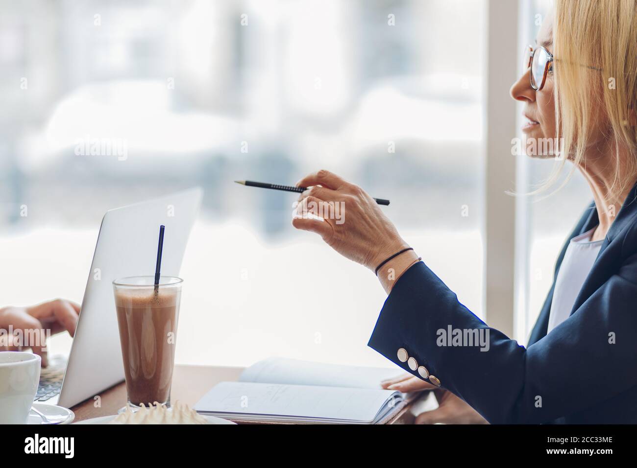 belle femme senior consultant un collègue en se reposant au café. vue rapprochée vue de côté rognée photo.femme conseillant un client de mettre en place une entreprise Banque D'Images